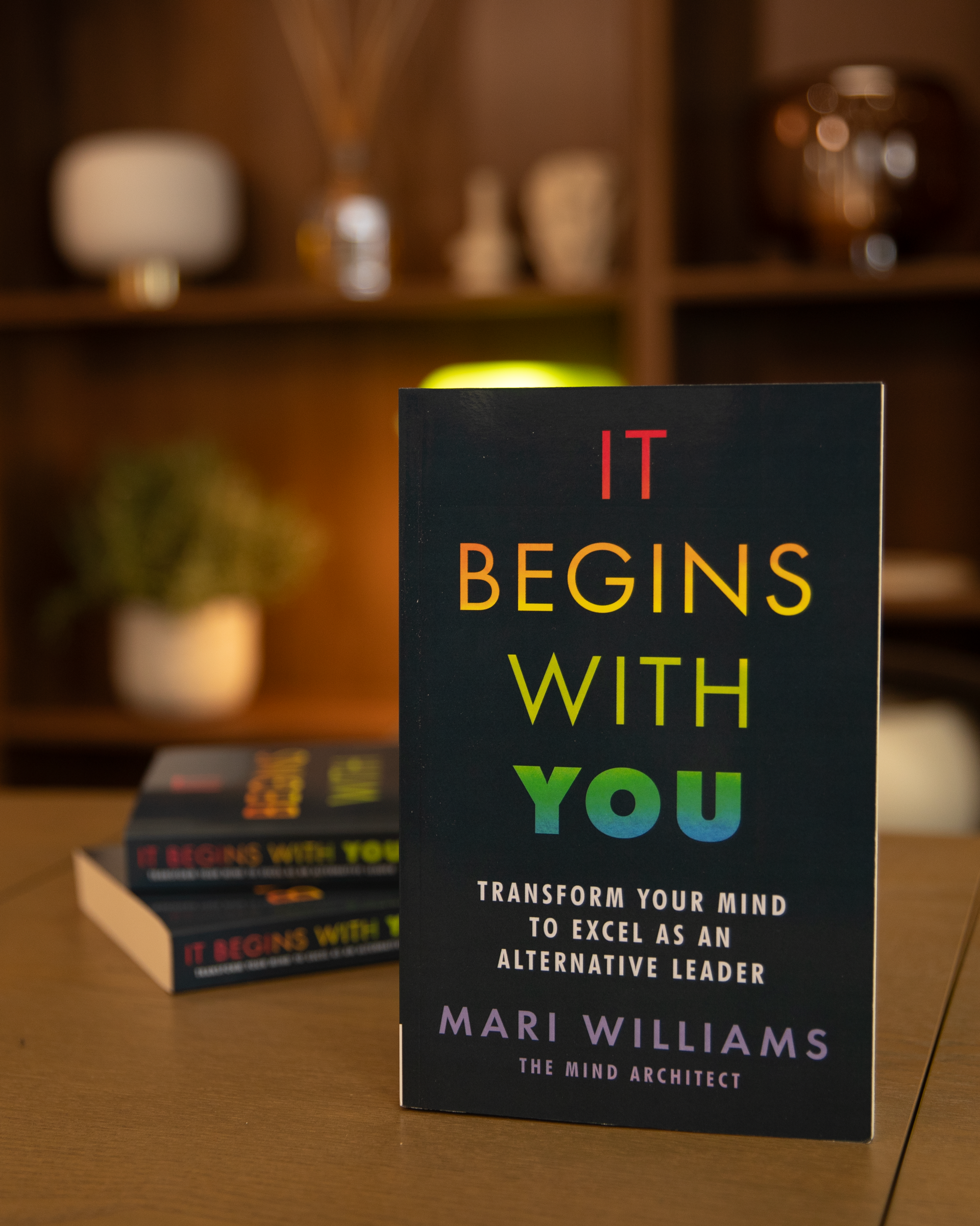 Mari Williams Leadership book, It Begins with You: transform your mind to excel as an alternative leader. 3 copies of the book on a table