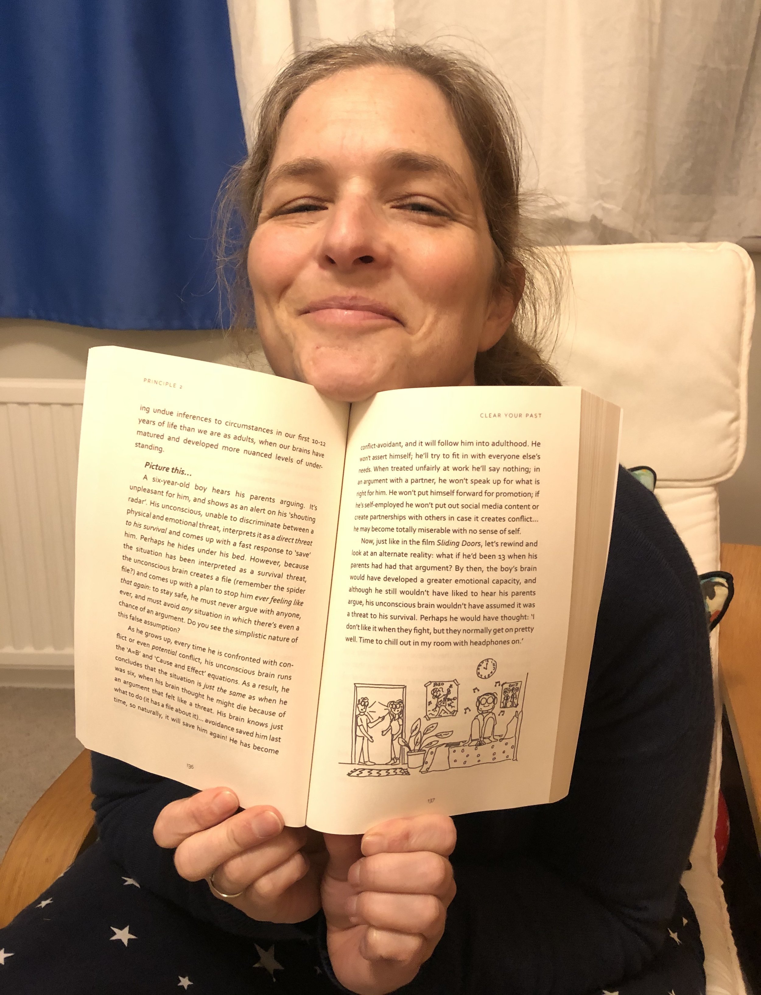 Mari Williams holding her leadership and therapy book, It Begins with You