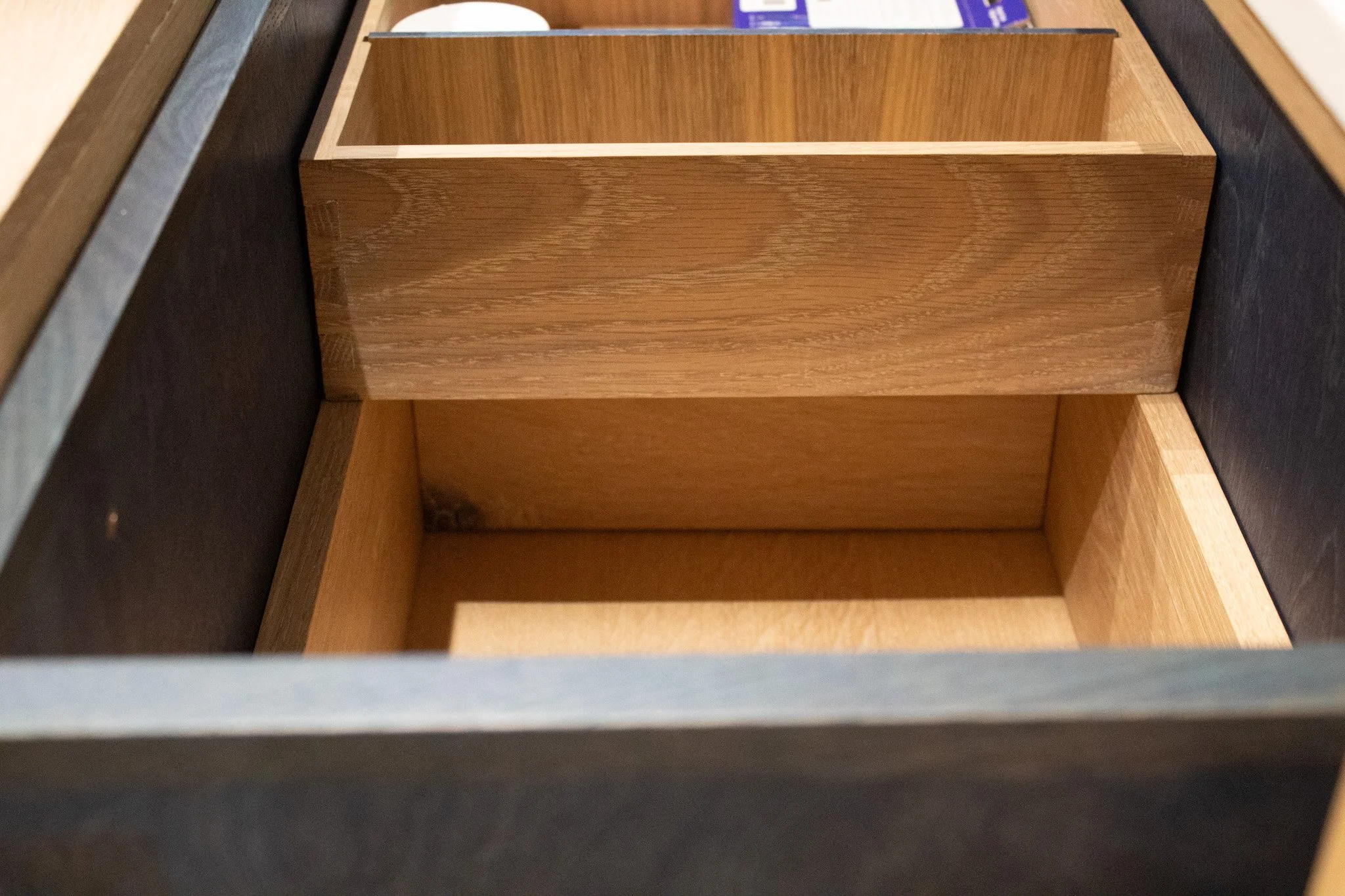 Inside of an open drawer showing a wooden compartment divided into two sections.