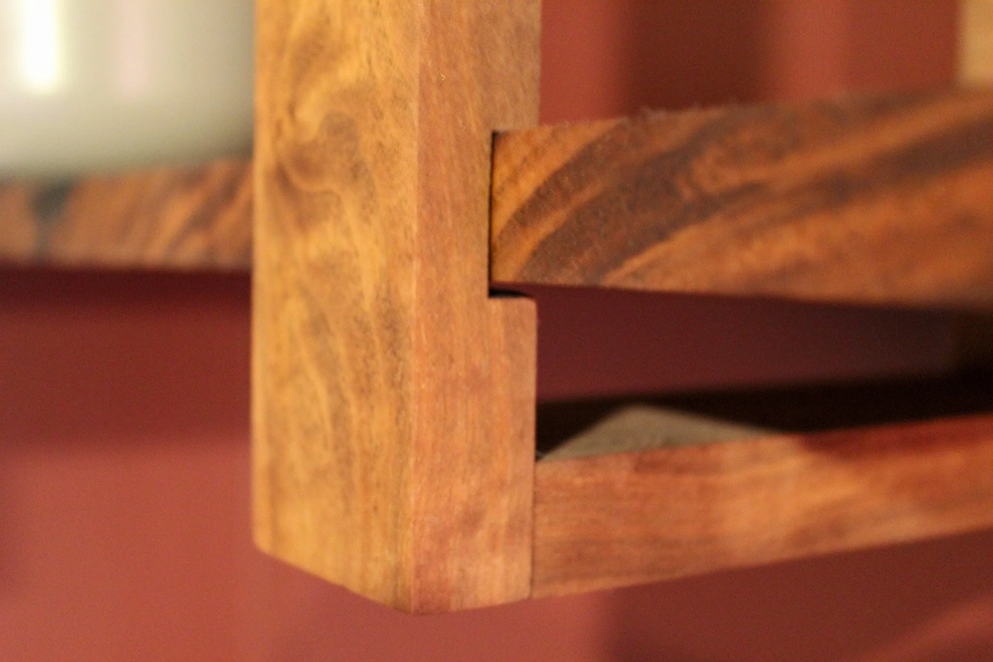 Close-up of a wooden piece with dovetail joint connecting two parts of a wooden furniture piece.
