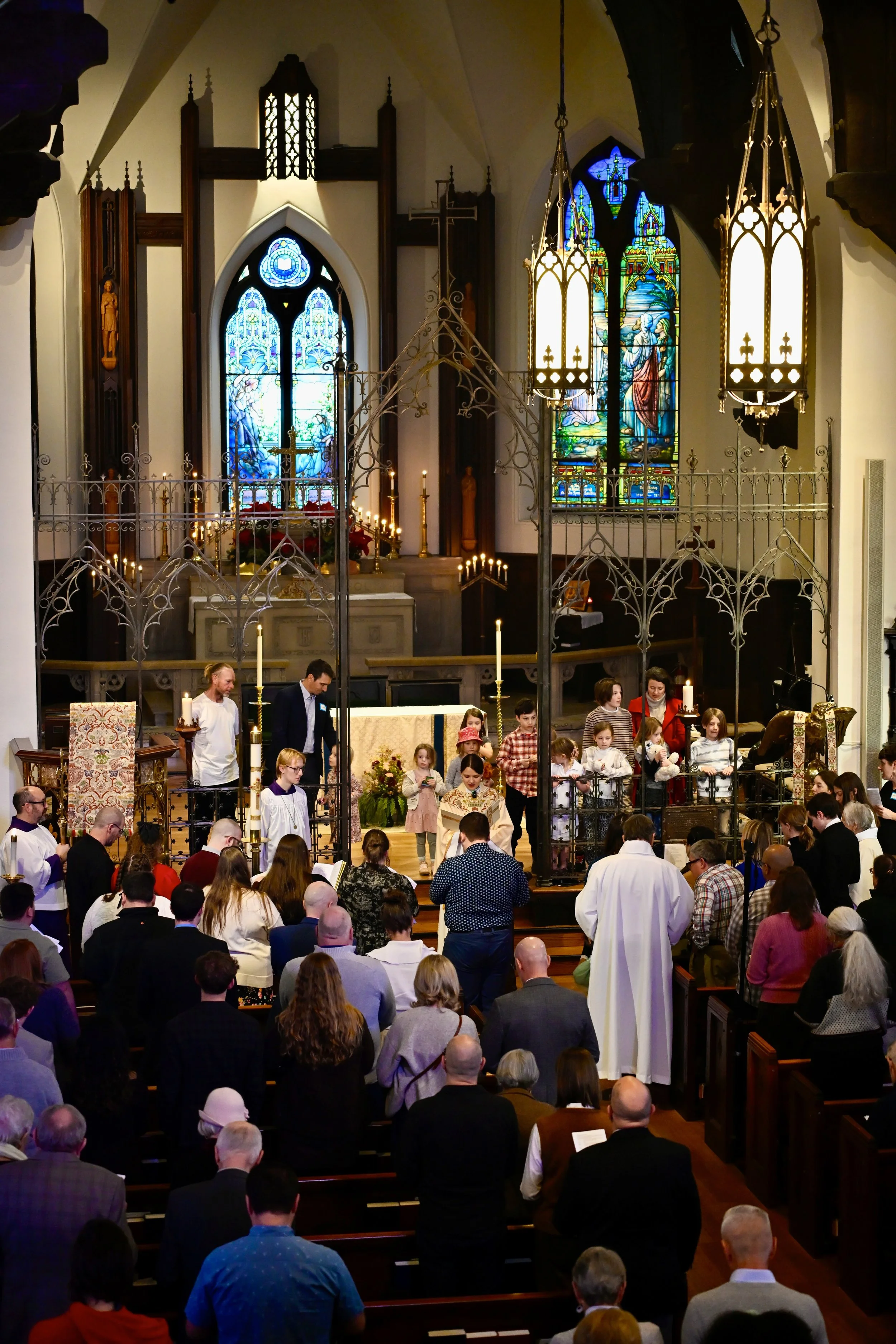 A church service with children participating at the altar, surrounded by congregation during a religious ceremony.