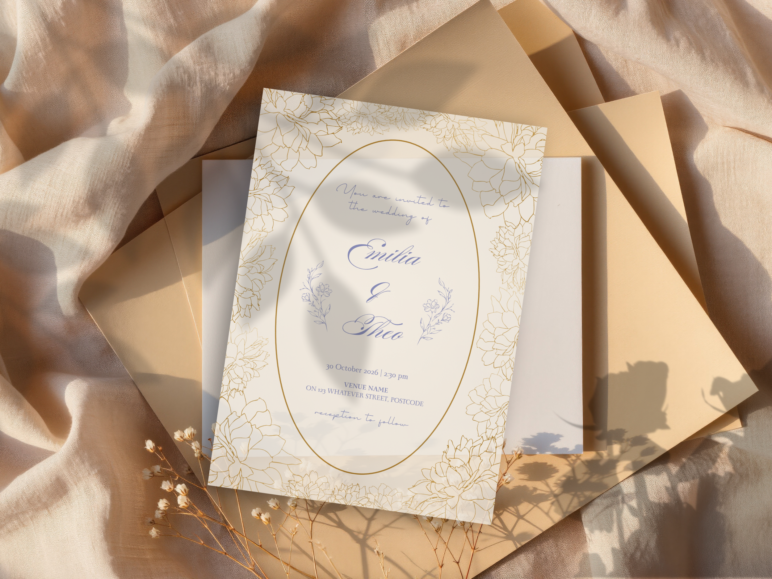 Wedding invitation card with a white background and gold floral border, placed on beige and cream-colored fabrics with shadows of small dried flowers.