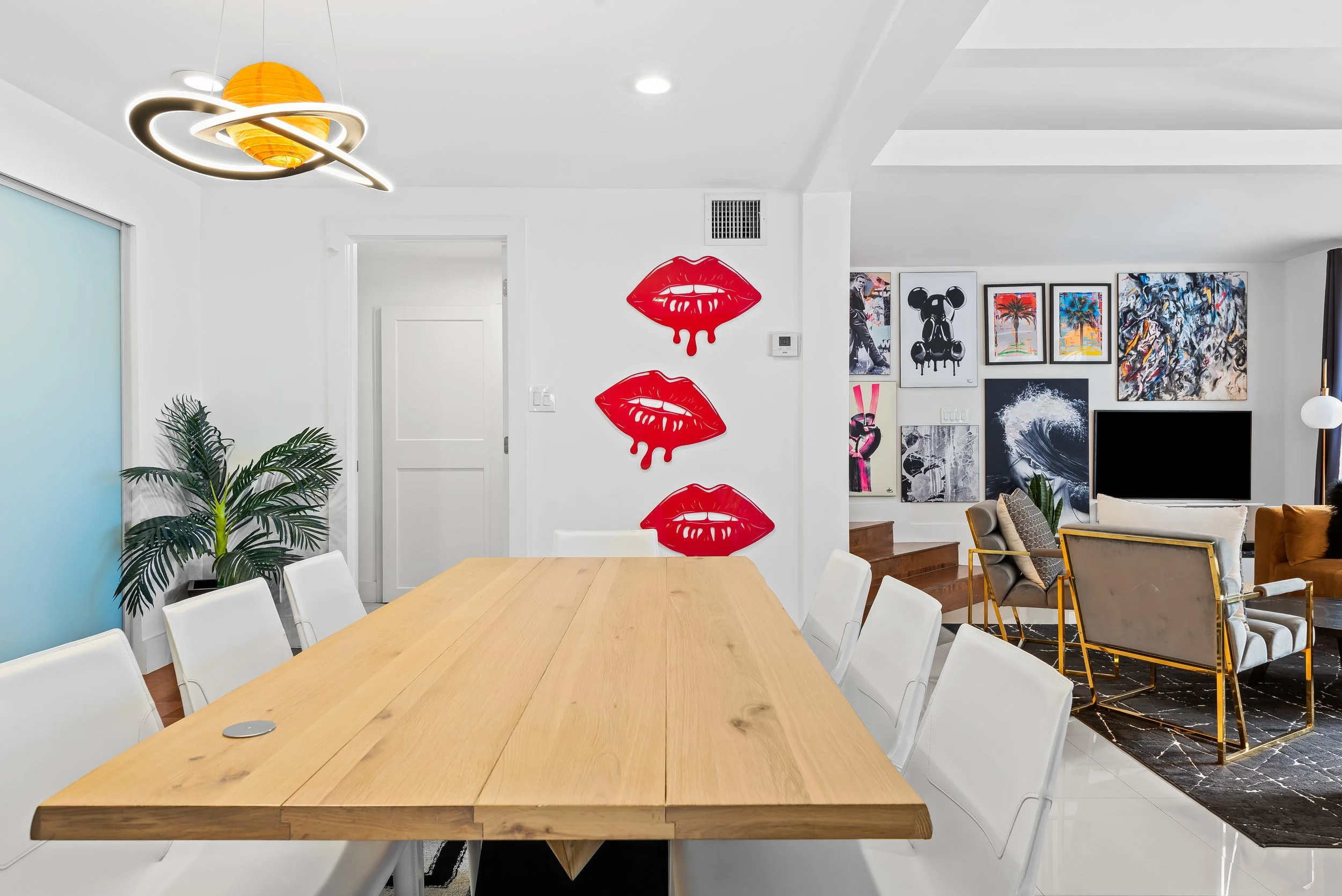 Modern dining room with pop art portrait and designer furnishings — Sun Haven Collection luxury vacation home.