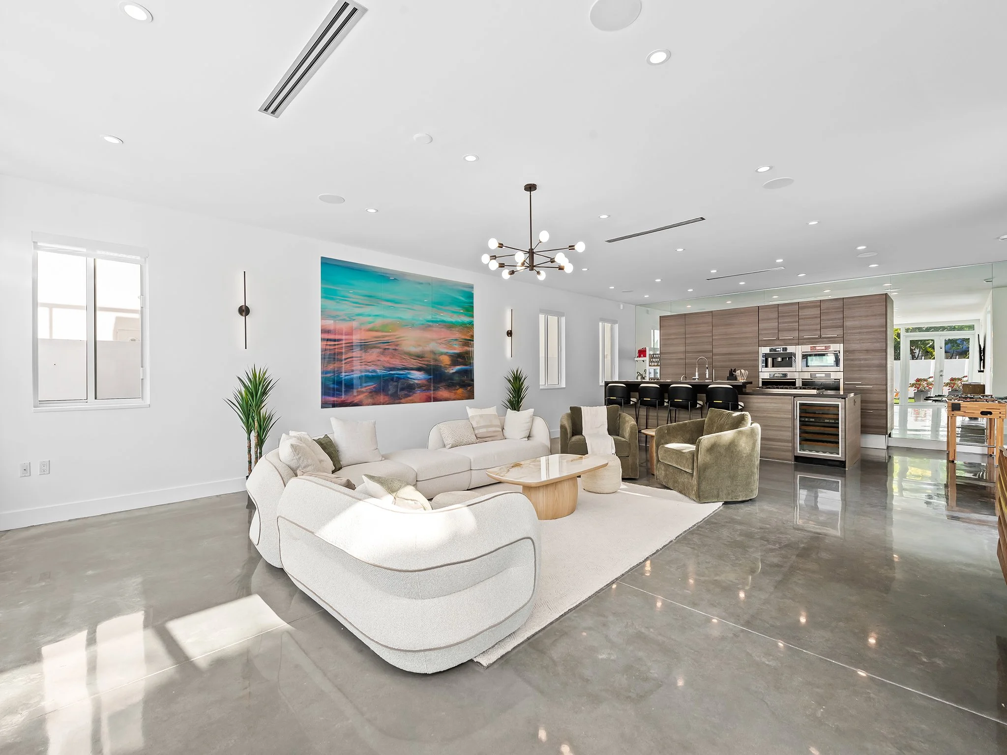 Modern living room with abstract art and designer seating — luxury vacation rental by Sun Haven Collection.
