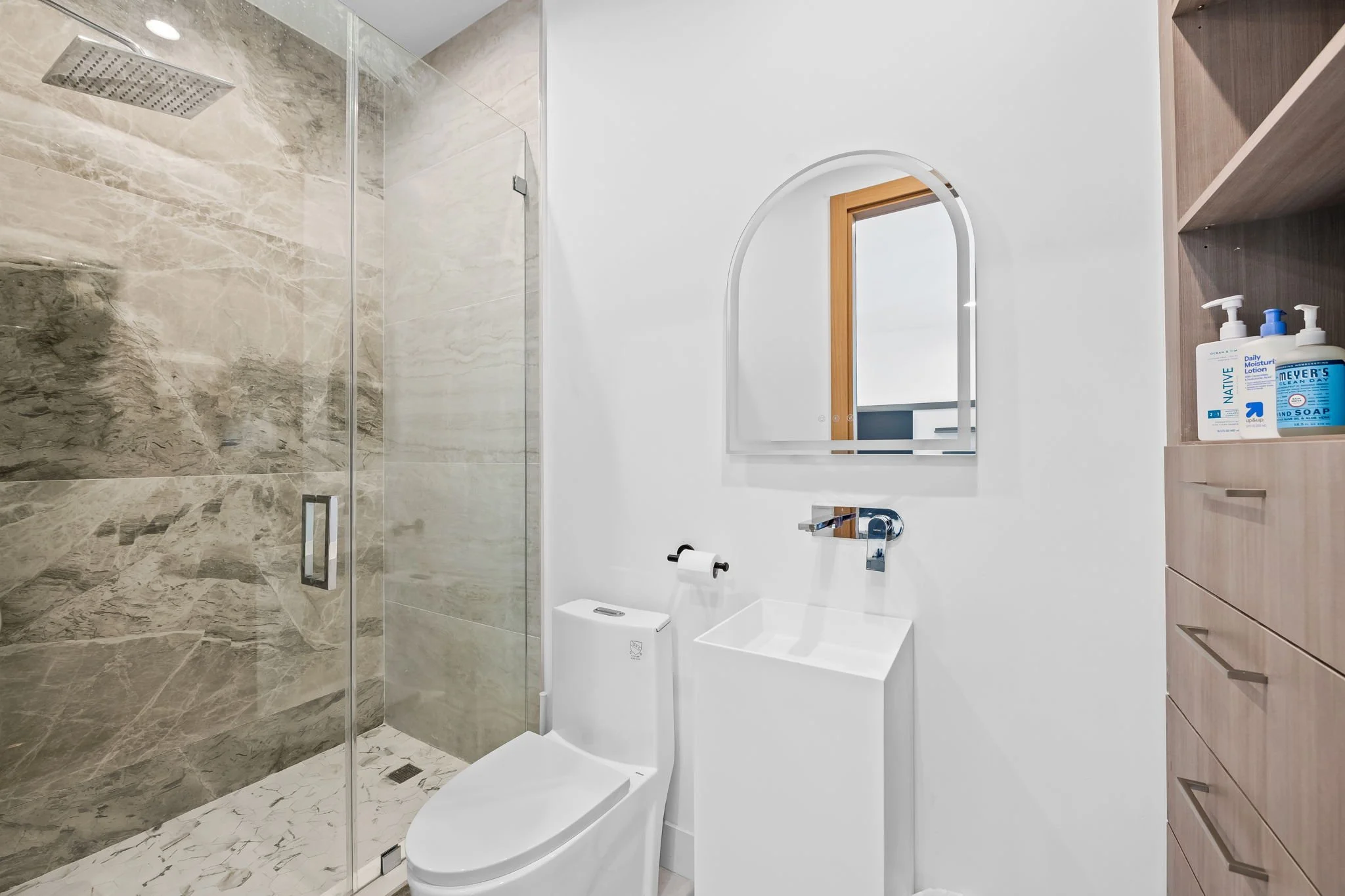 Walk-in rain shower with marble tile and premium bath amenities — Sun Haven Collection luxury vacation rental.