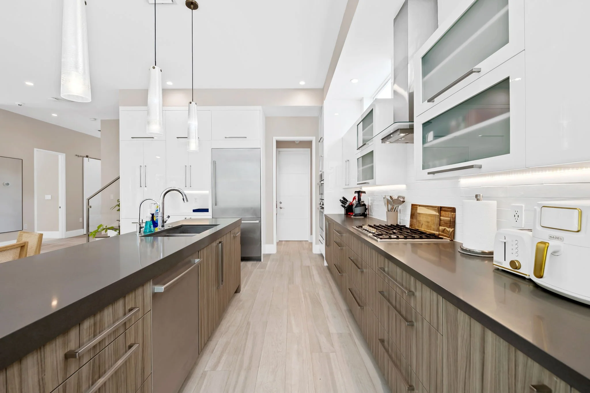 Gourmet kitchen with center island and pendant lighting — luxury vacation home by Sun Haven Collection.