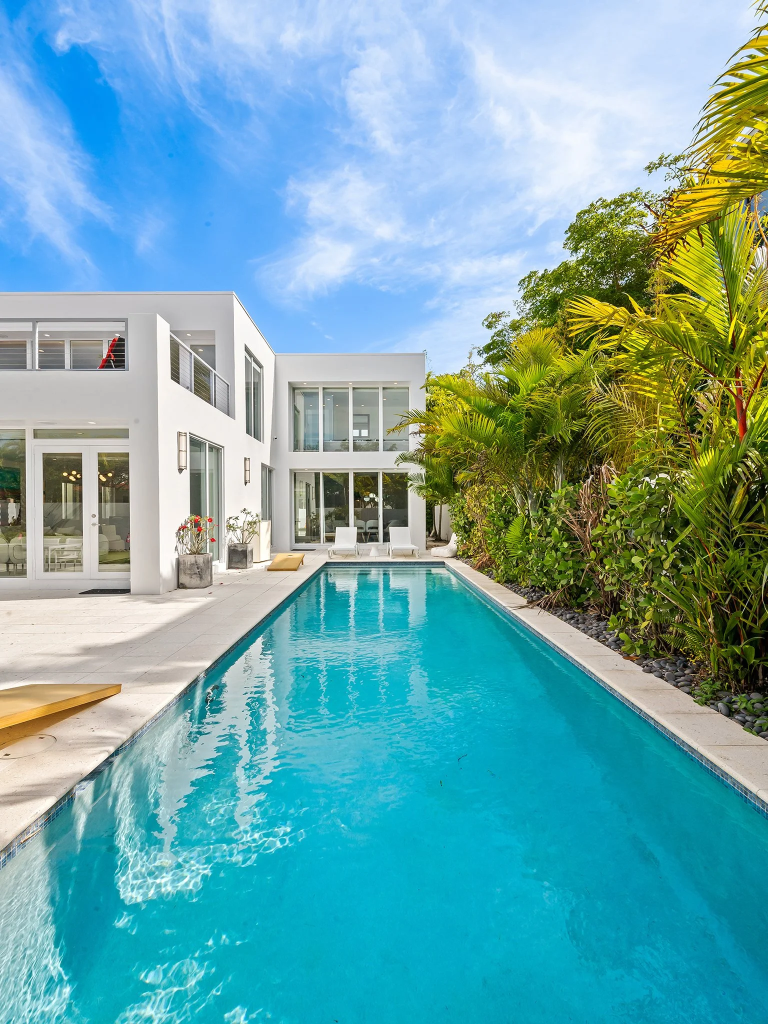 Contemporary vacation home exterior with pool and glass doors — luxury rental, Sun Haven Collection.