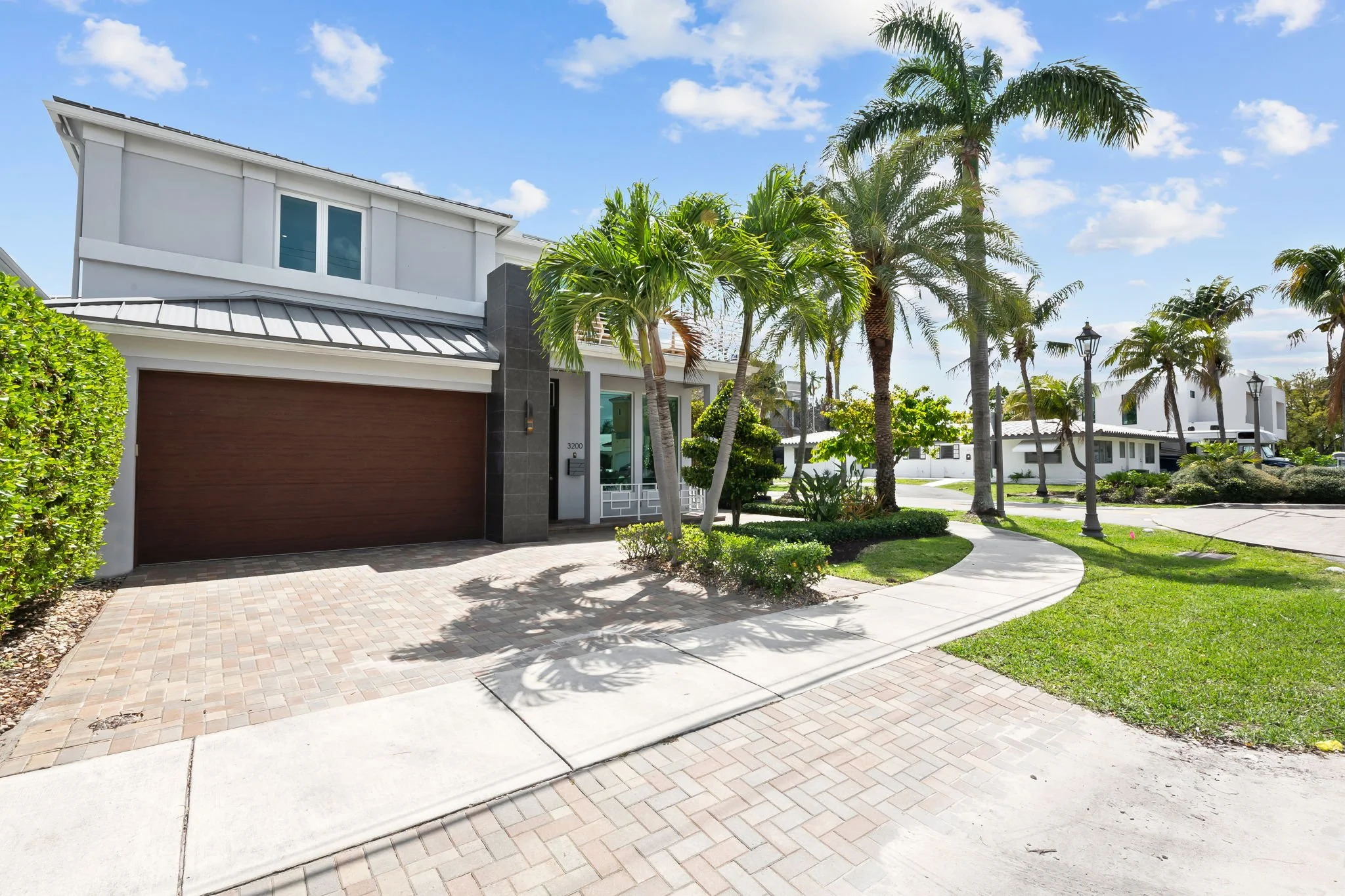 Luxury vacation home curb appeal with manicured lawn — Sun Haven Collection rental, Fort Lauderdale.