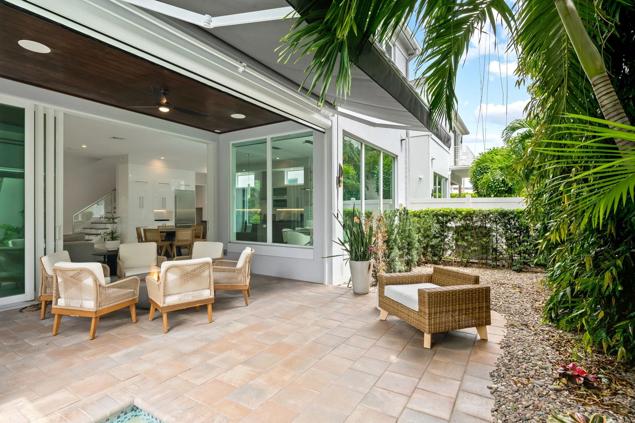 Tropical patio with fire pit and wicker seating — Sun Haven Collection luxury vacation rental.