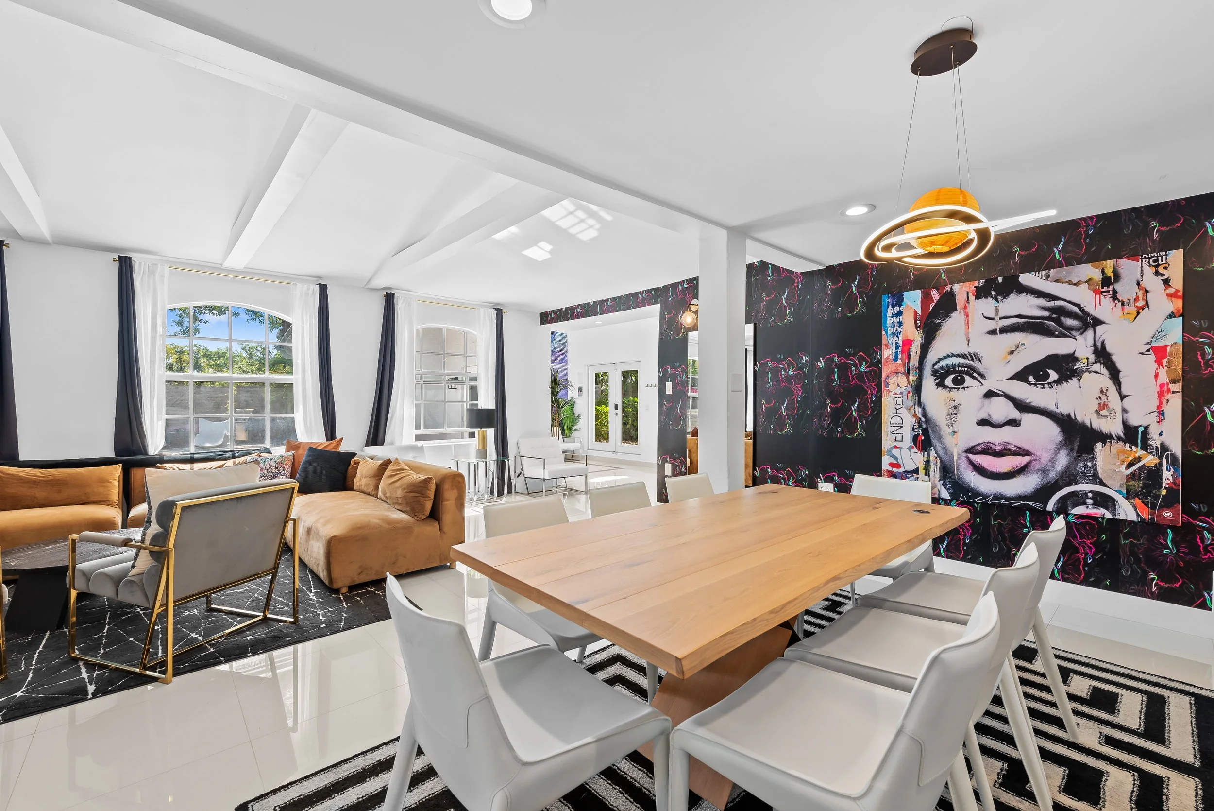 Bold living room with portrait mural and designer leather seating — Sun Haven Collection art-inspired rental.