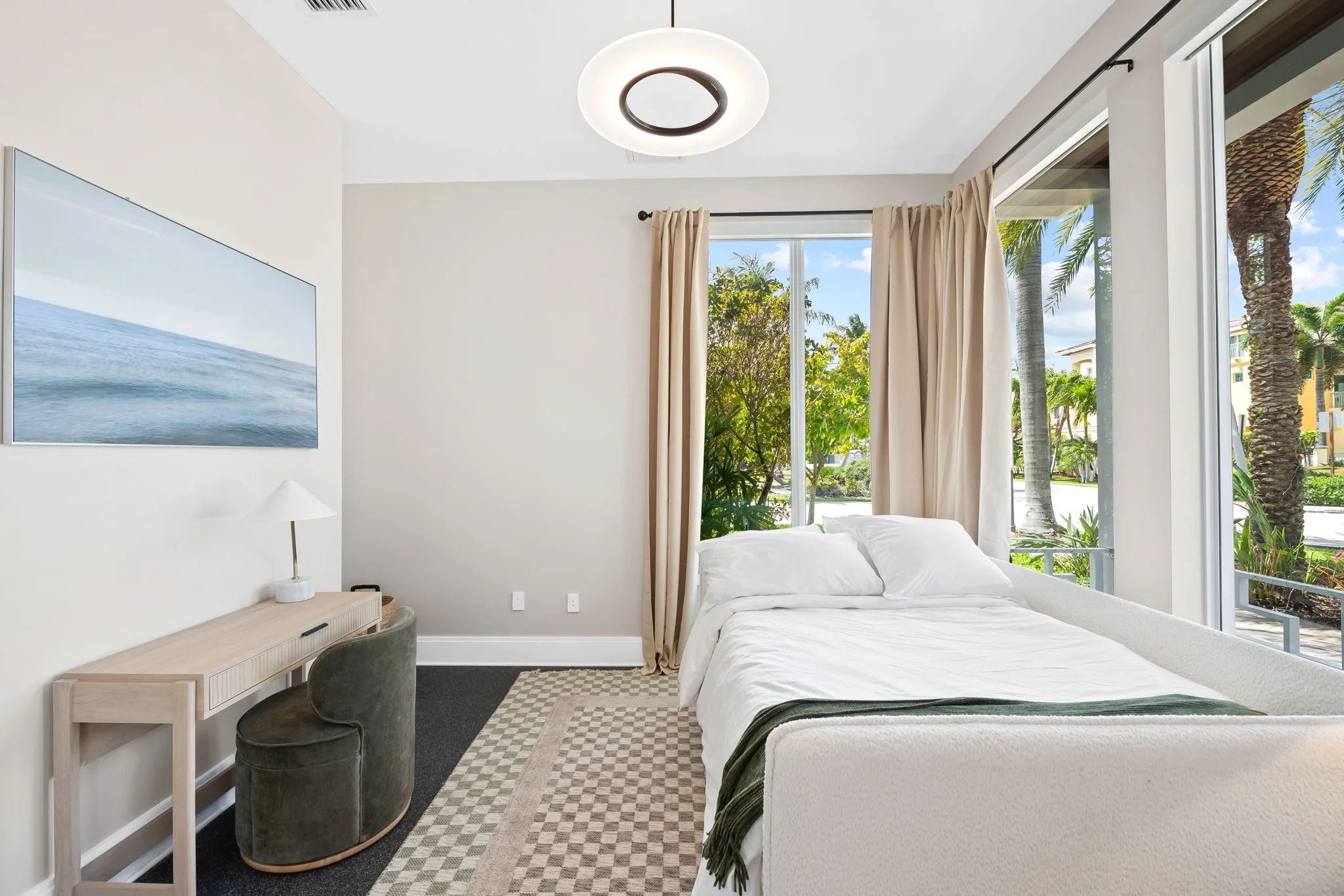 Coastal bedroom with ocean art and palm tree views — luxury vacation home by Sun Haven Collection.