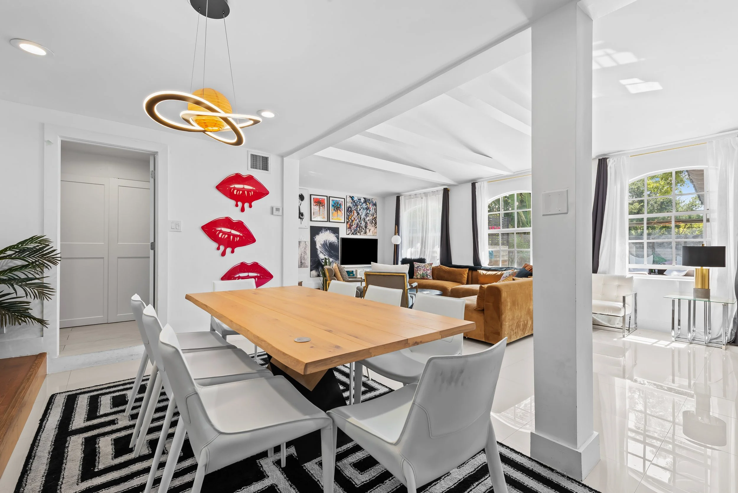 Designer living room with pop art decor, gold accents, and large windows — luxury vacation home, Sun Haven Collection.