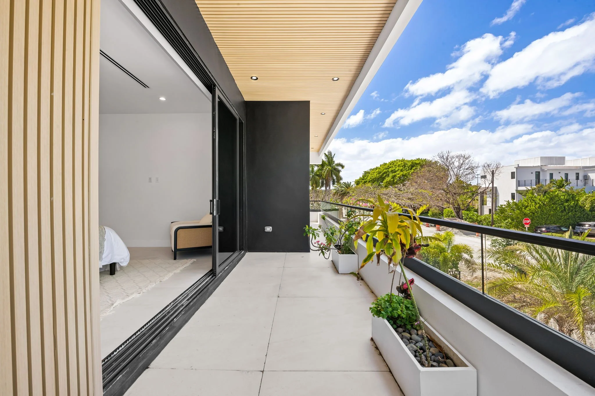 Upper balcony with tropical plants and treetop views — luxury vacation home, Sun Haven Collection