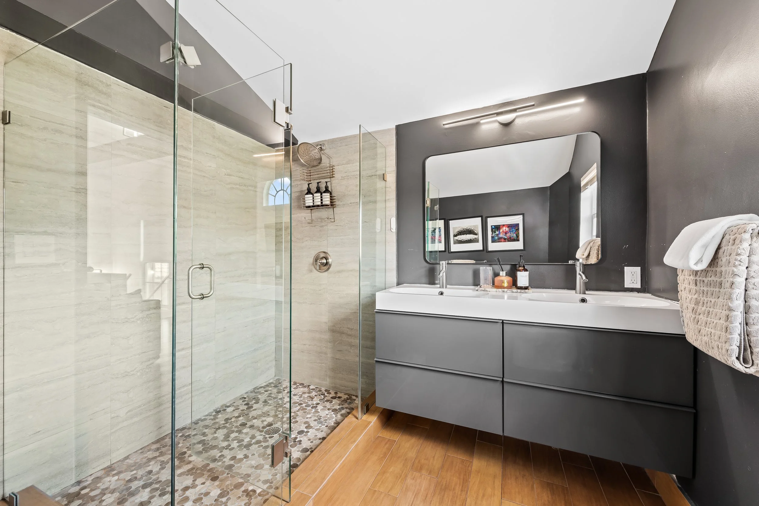 Spa bathroom with pebble-floor shower and dual vanity — Sun Haven Collection luxury vacation rental.
