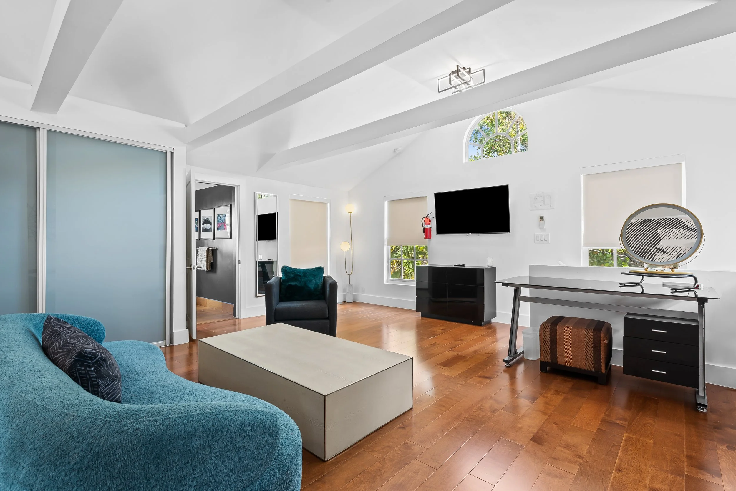 Modern living room with turquoise sofa and garden views — luxury vacation home by Sun Haven Collection.