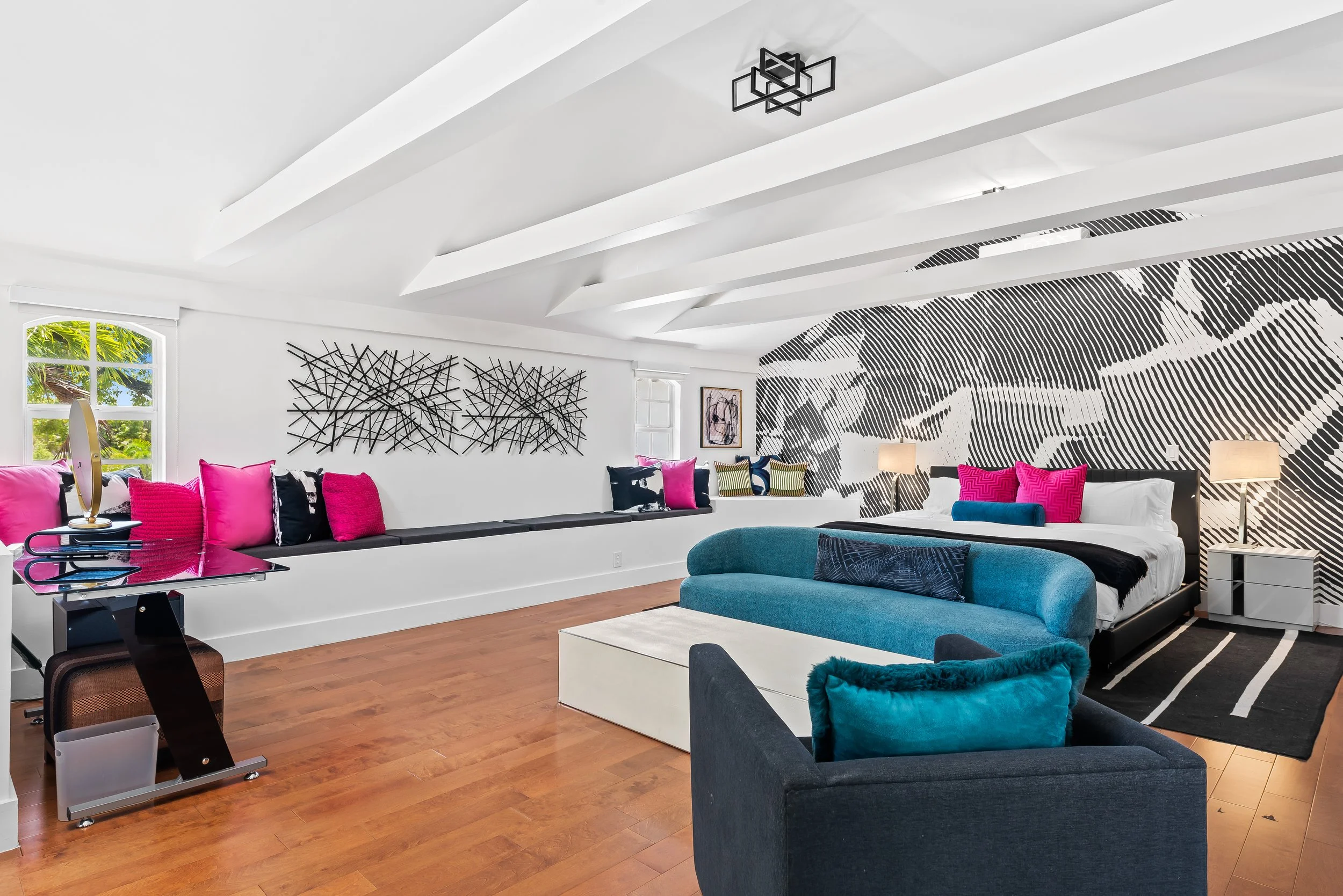 Living room with large-scale black and white mural and colorful accents — Sun Haven Collection luxury rental.