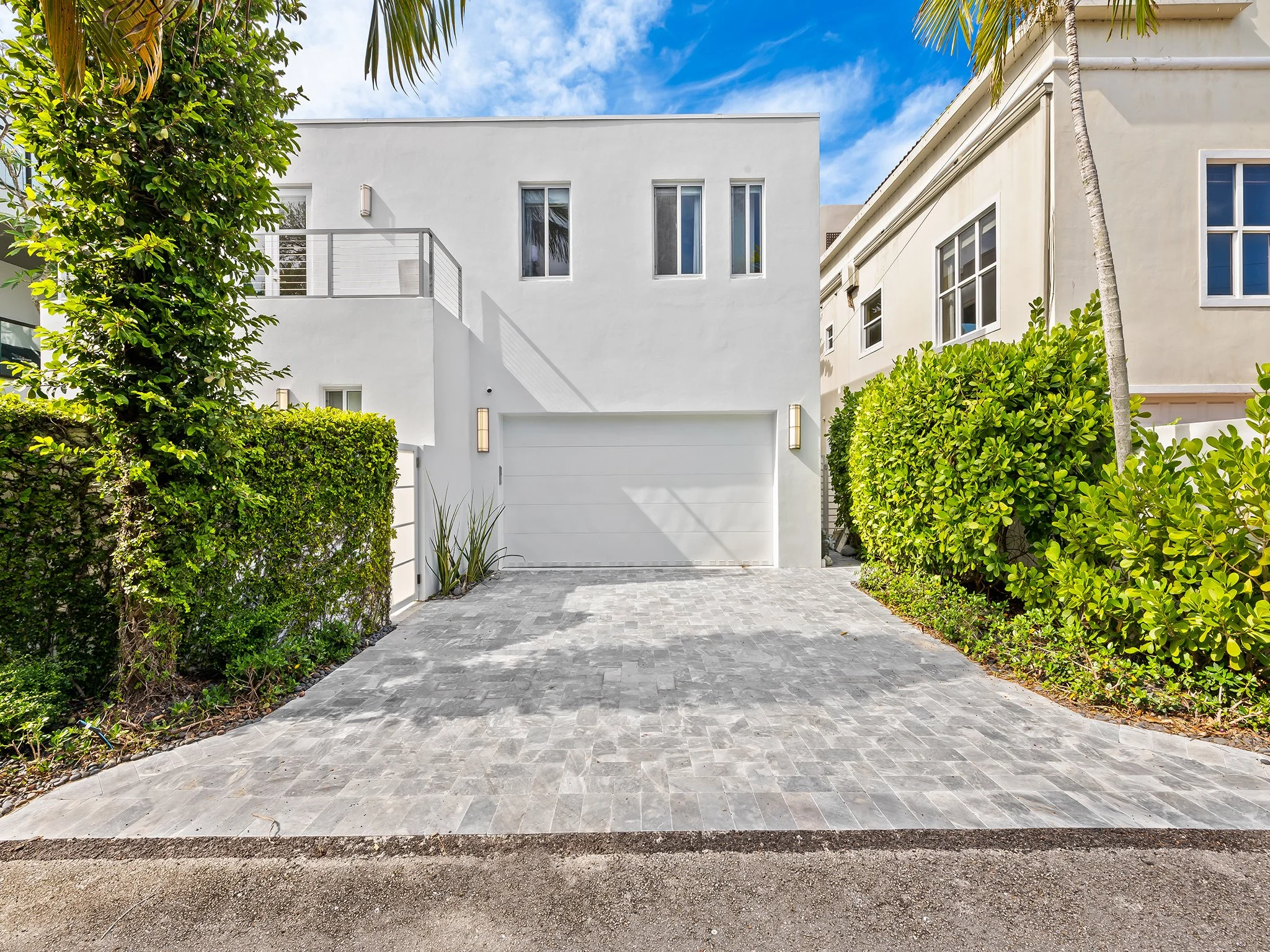 Luxury vacation home entrance with stone driveway and balcony — Sun Haven Collection, Fort Lauderdale.