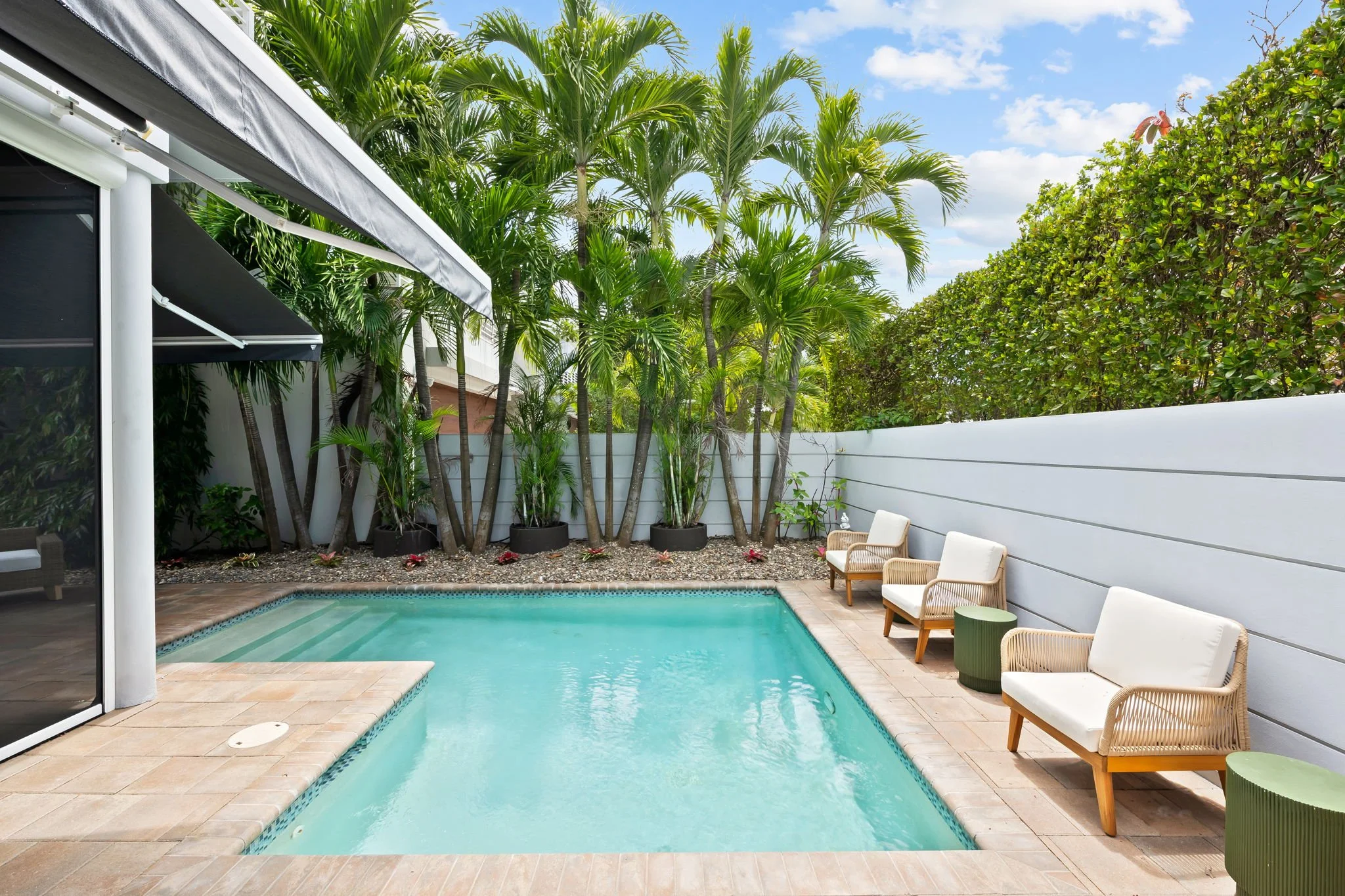 Backyard pool with palm trees and lounge seating — luxury vacation home by Sun Haven Collection.