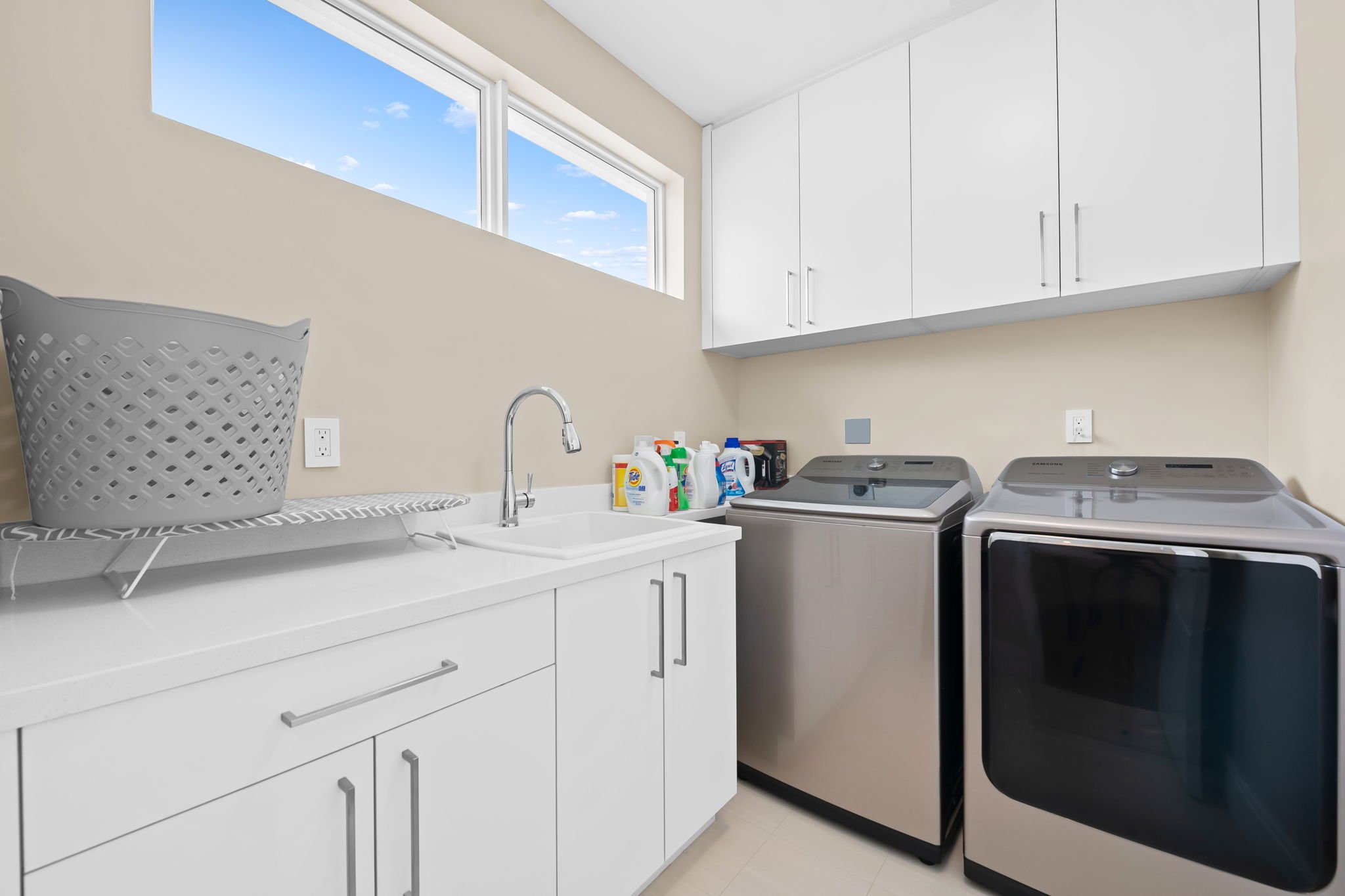 Full laundry room with washer, dryer, and utility sink — Sun Haven Collection luxury vacation home amenity.
