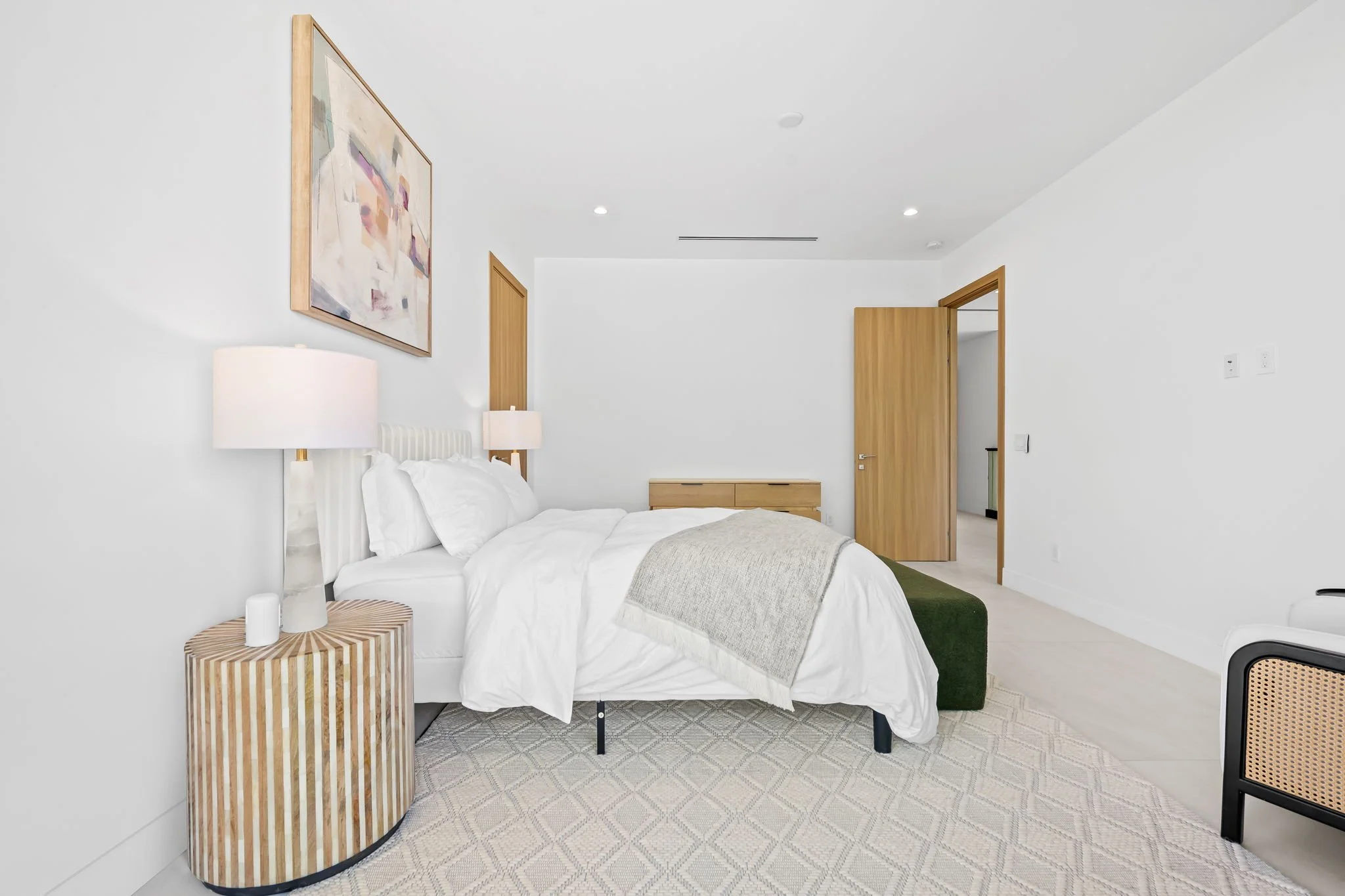 Minimalist-designed bedroom with wooden accents — design-forward vacation home by Sun Haven Collection.
