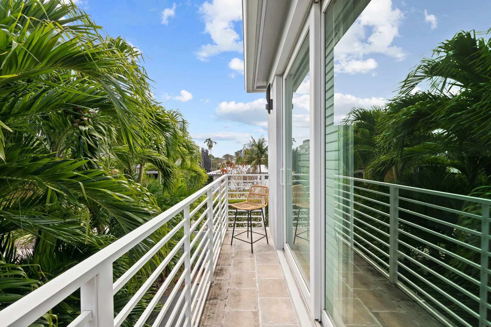 Private balcony with tropical treetop views — Sun Haven Collection luxury vacation rental, Fort Lauderdale.