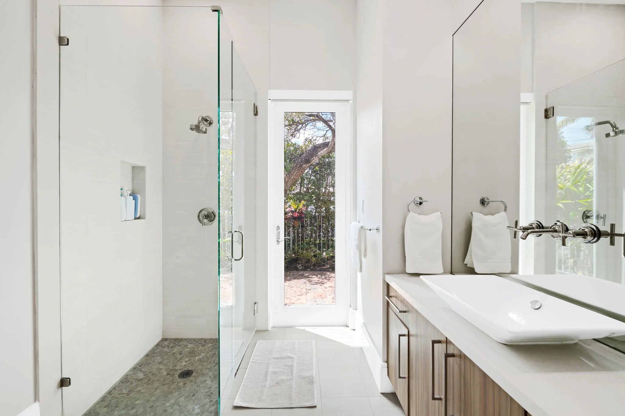 Modern bathroom with walk-in shower and garden views — Sun Haven Collection luxury vacation rental.
