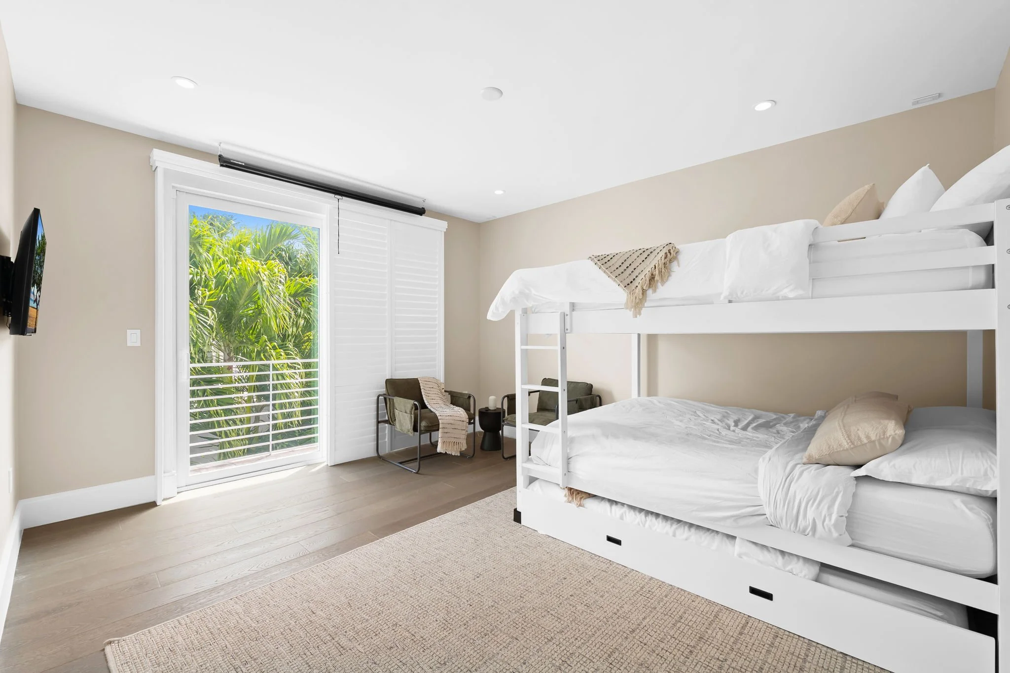 Bunk room with patio access and tropical views — Sun Haven Collection family vacation rental.