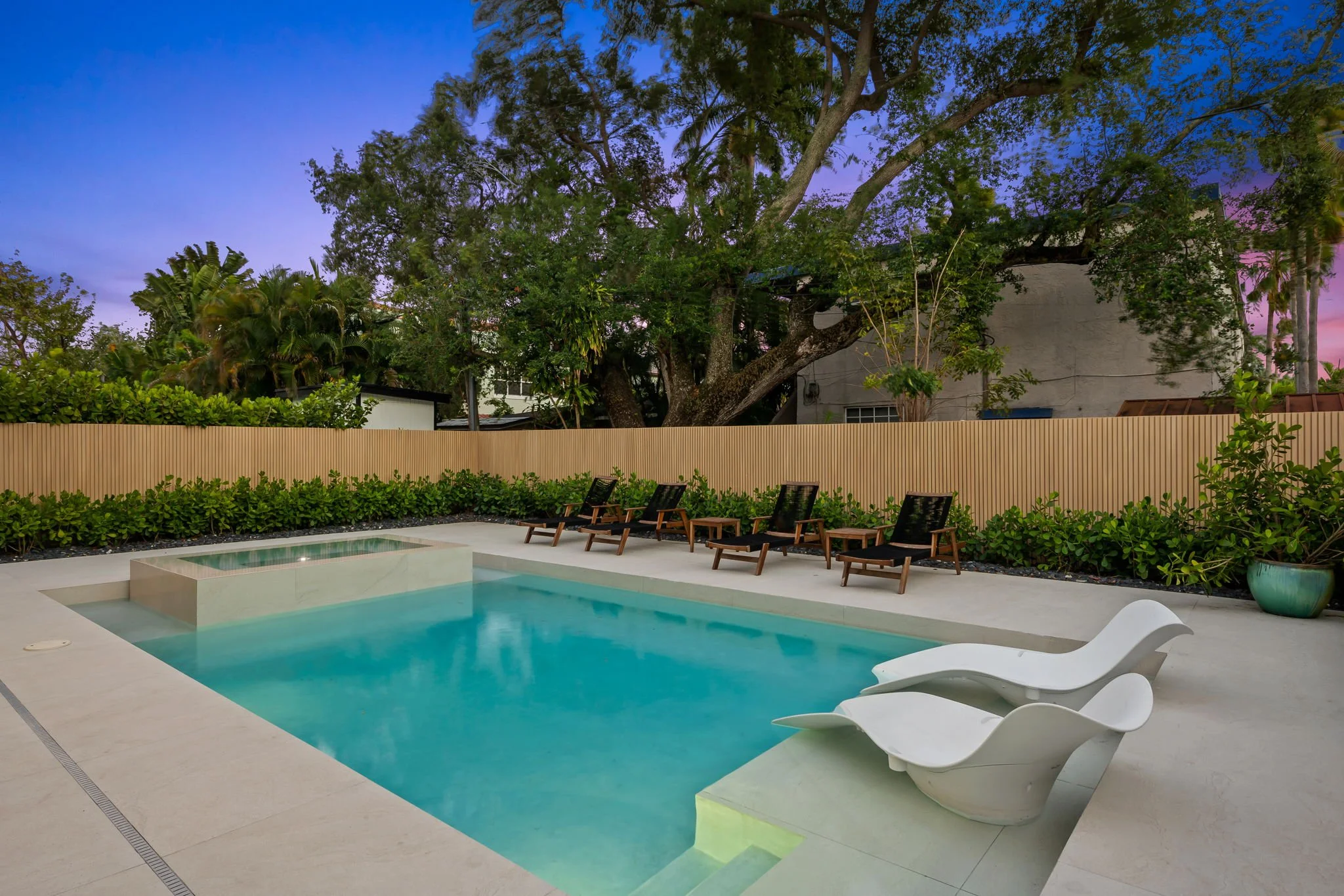Private pool and lounge area surrounded by tropical greenery at dusk — Sun Haven Collection vacation rental.