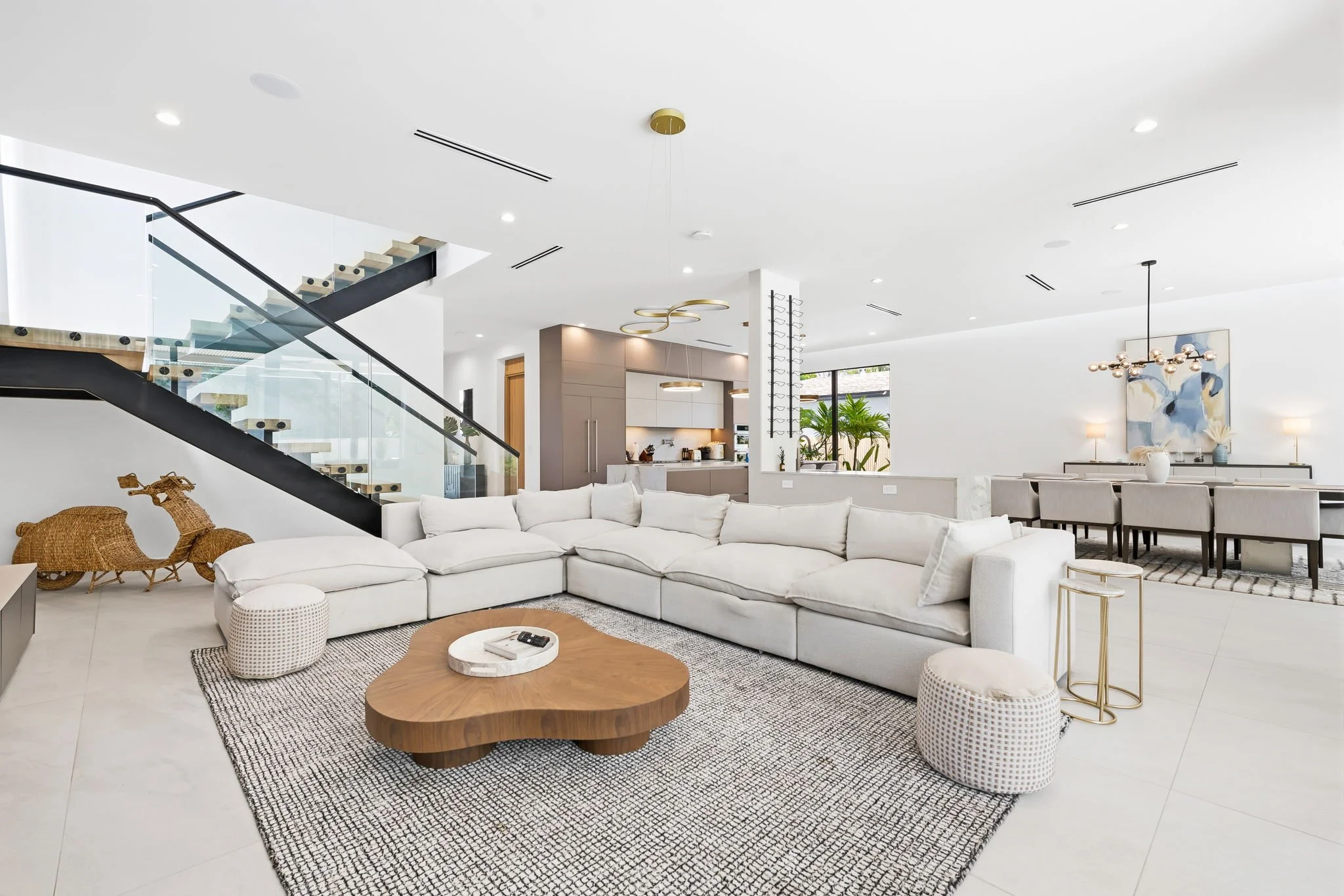 Bright open-concept living area with curated interiors and pendant-lit kitchen — luxury vacation home, Sun Haven Collection.