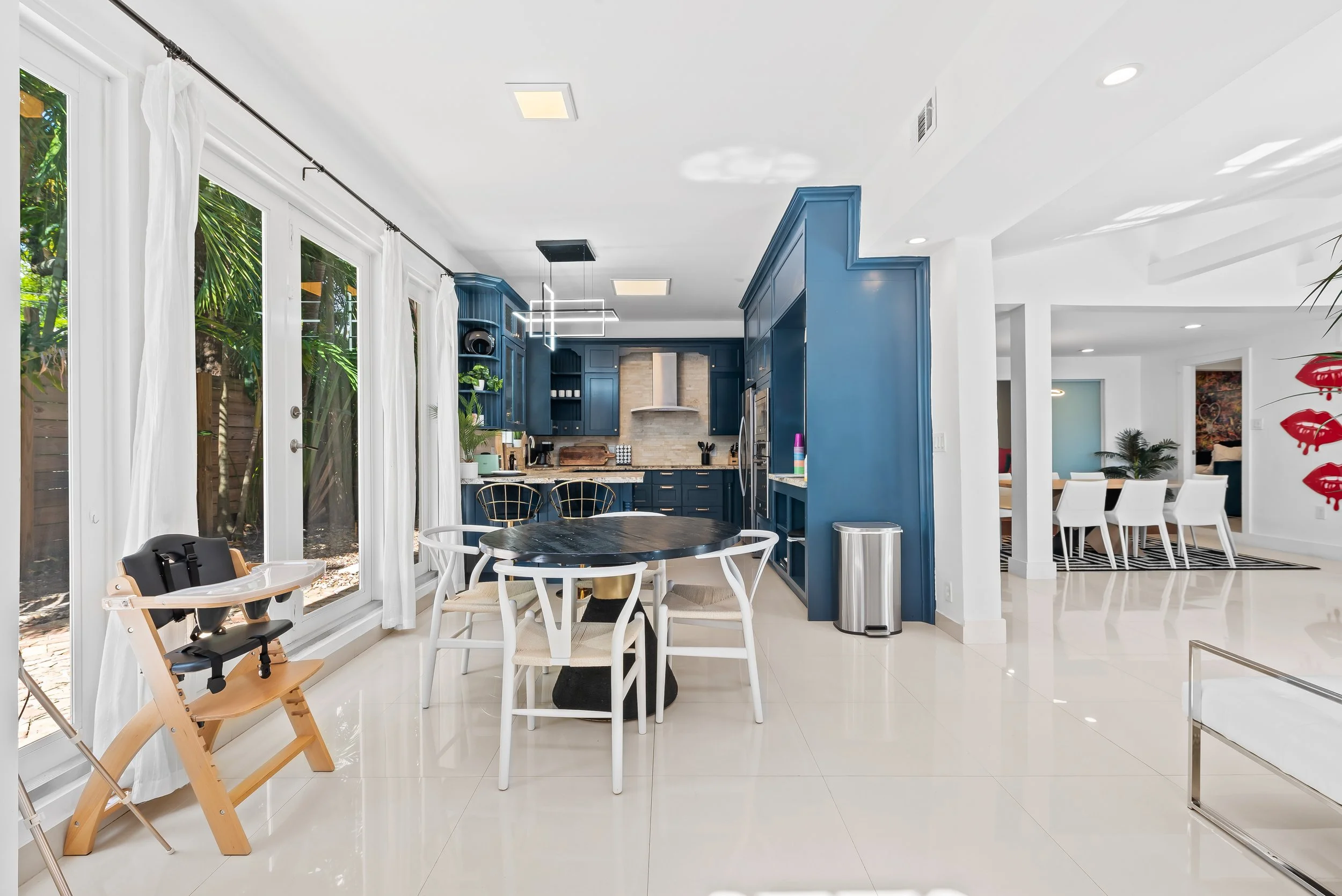 Open-concept kitchen and dining with garden views — luxury vacation home by Sun Haven Collection.