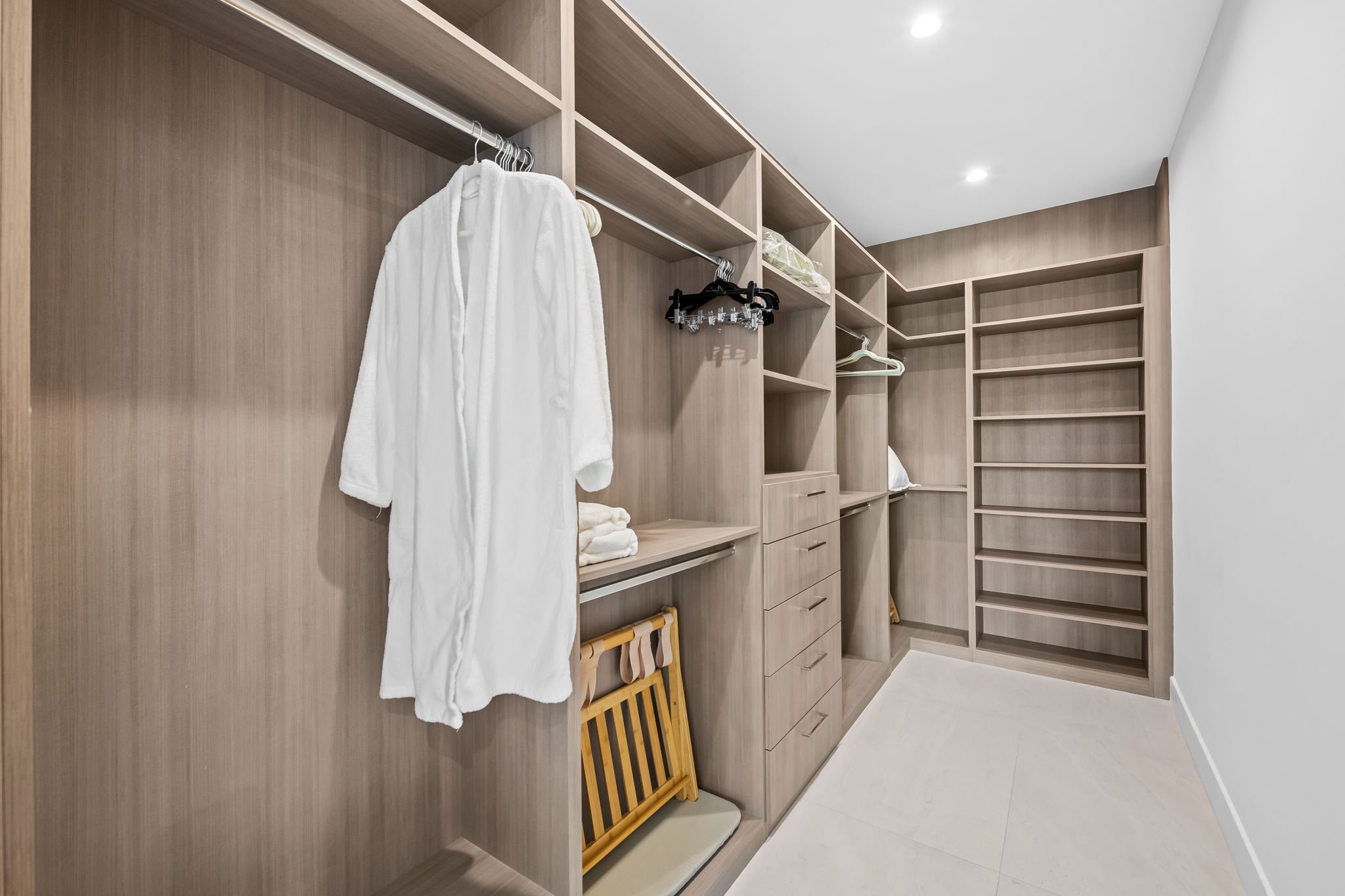 Walk-in closet with built-in storage and plush robes — luxury vacation home by Sun Haven Collection.