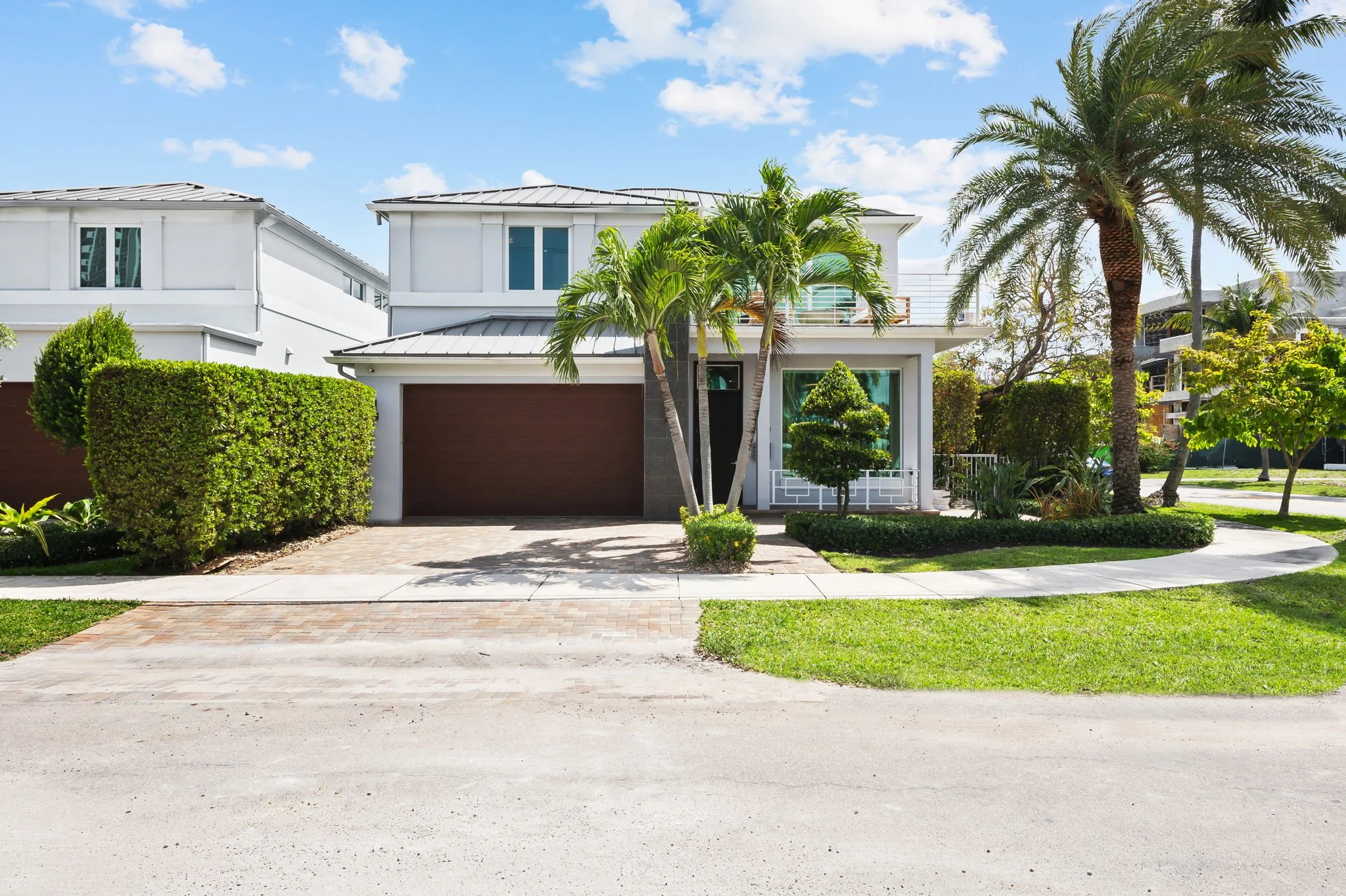 Two-story luxury vacation home surrounded by tropical landscaping — Sun Haven Collection rental.