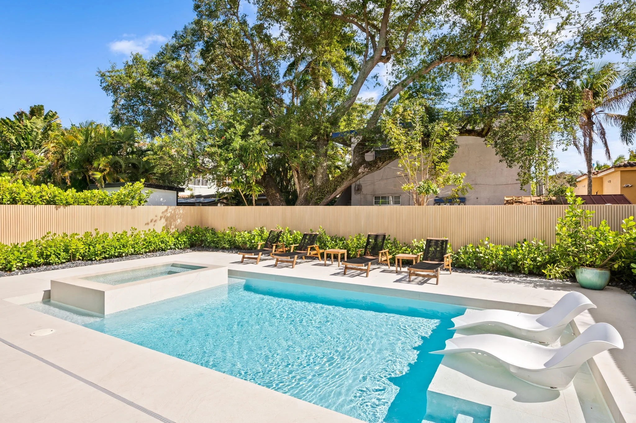 Private pool with sun loungers surrounded by lush tropical landscaping — Sun Haven Collection vacation rental.