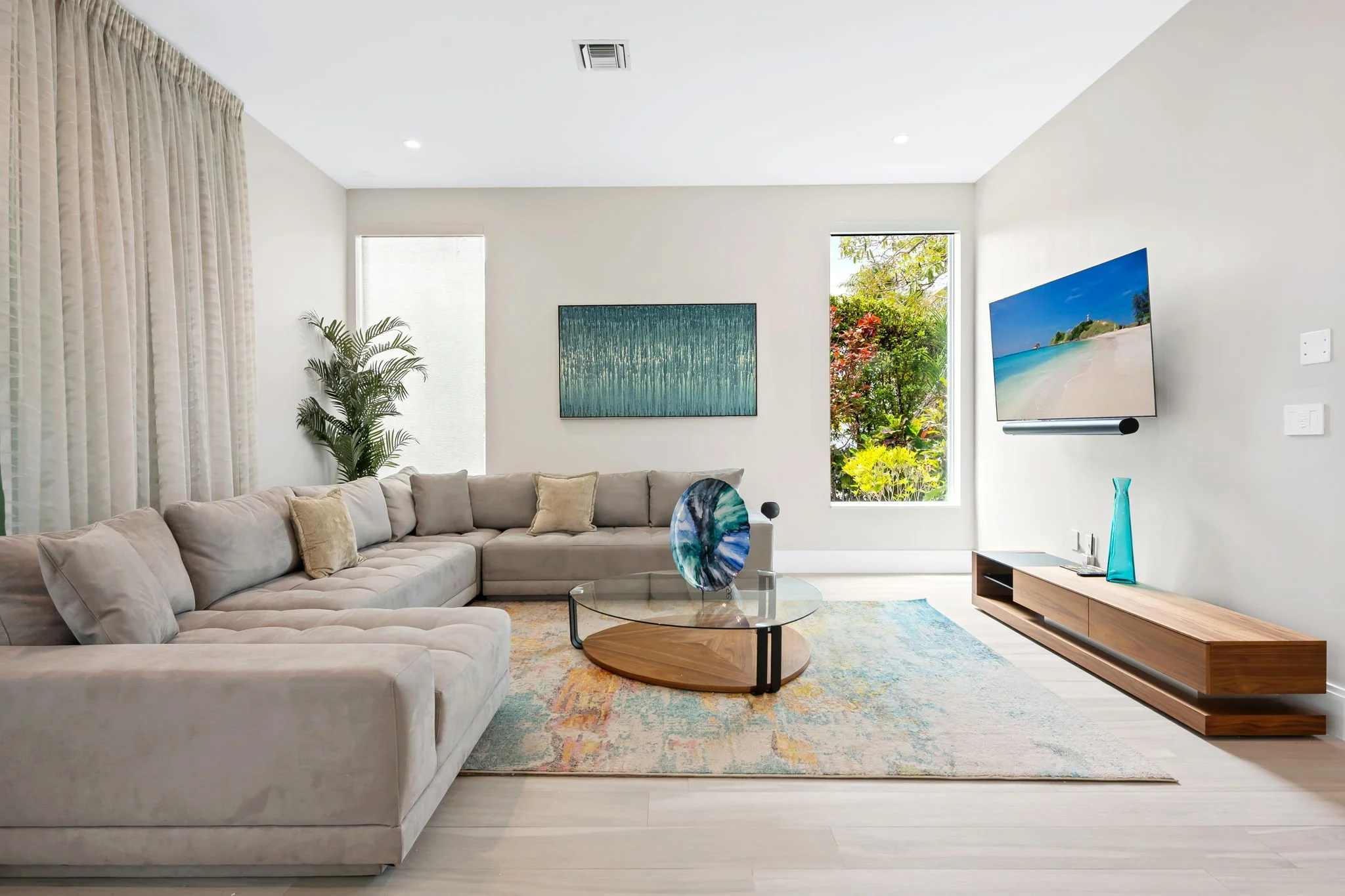 Coastal living room with smart TV and designer furnishings — Sun Haven Collection luxury vacation rental.