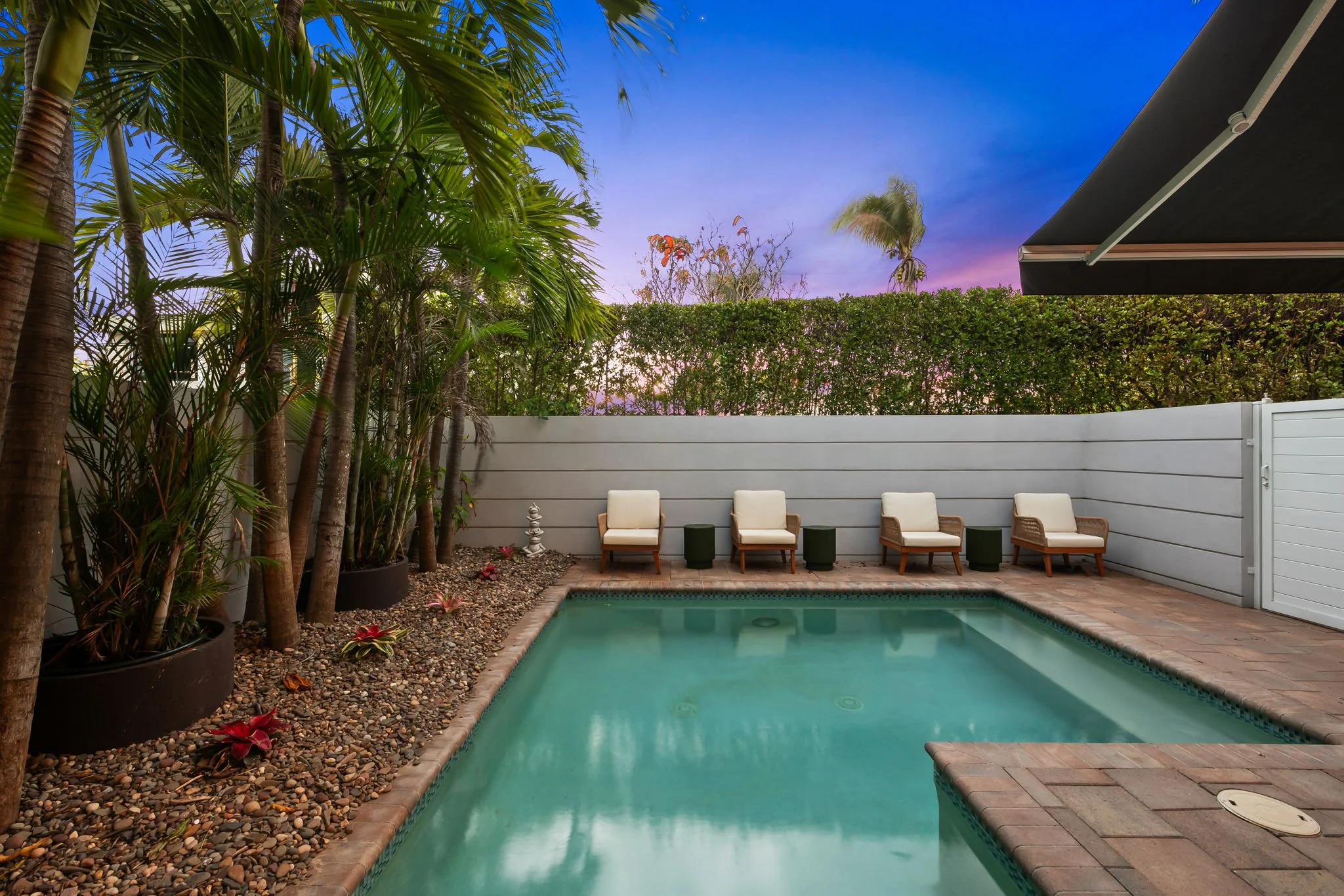 Private pool at sunset with tropical privacy hedge — luxury vacation home by Sun Haven Collection.