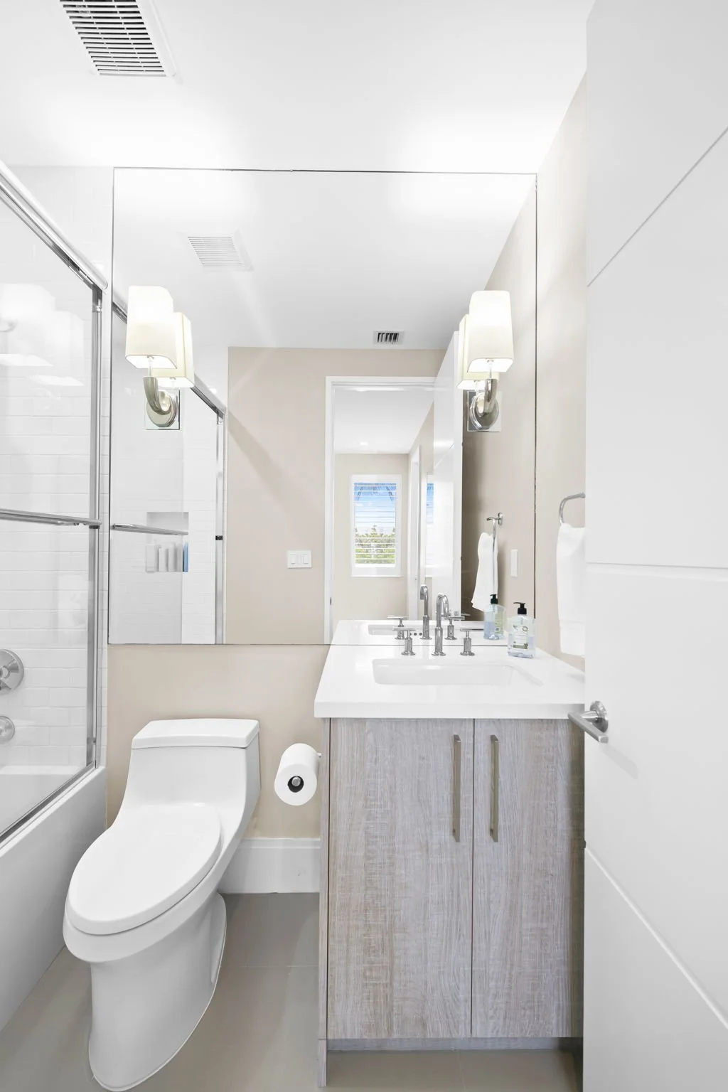 Full bathroom with glass shower and natural light — luxury vacation rental by Sun Haven Collection.