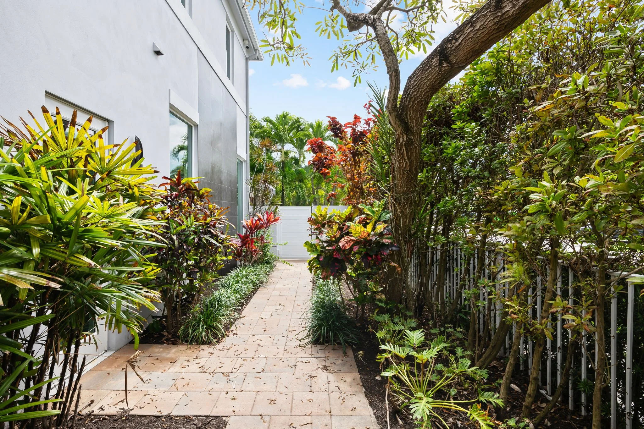 Lush garden pathway with flowering plants — Sun Haven Collection luxury vacation home landscaping.