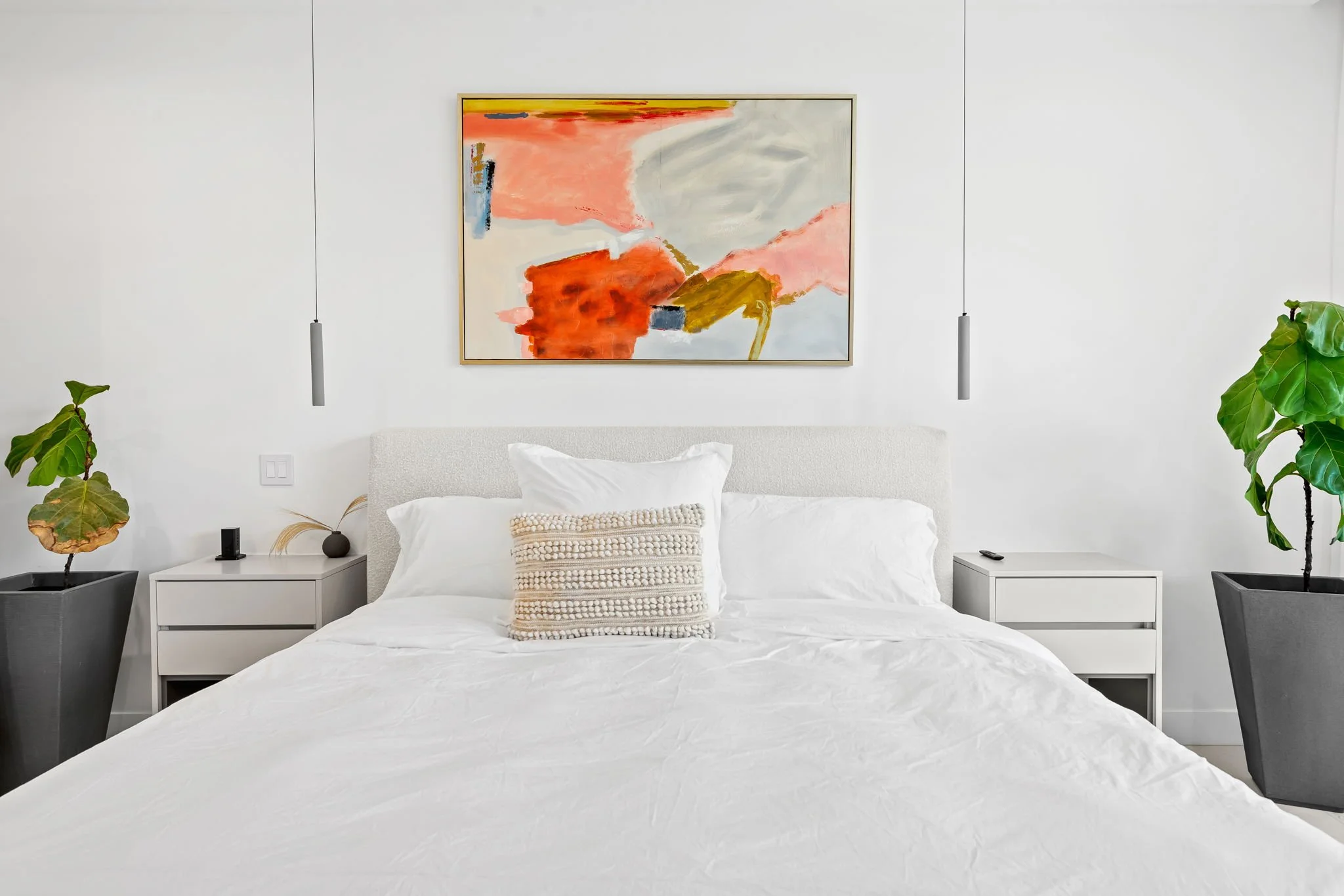 Modern bedroom with pendant lighting and abstract wall art — luxury vacation rental by Sun Haven Collection.