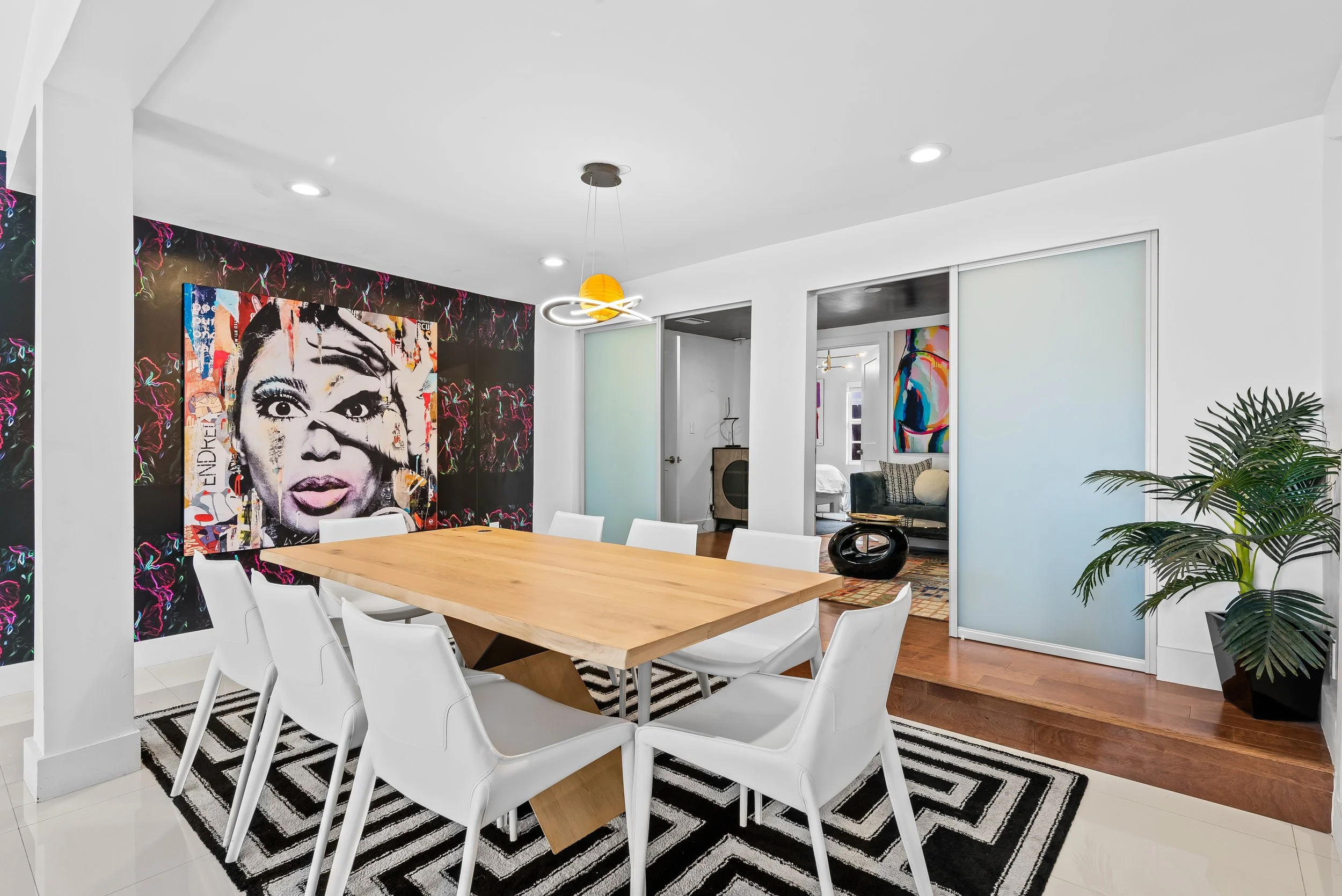 Modern dining room with a wooden table and  colorful pop art details — Sun Haven Collection luxury vacation home.