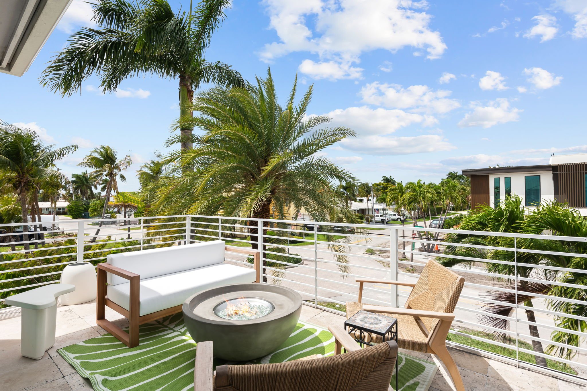 Private balcony with palm tree views and outdoor seating — luxury vacation home by Sun Haven Collection.