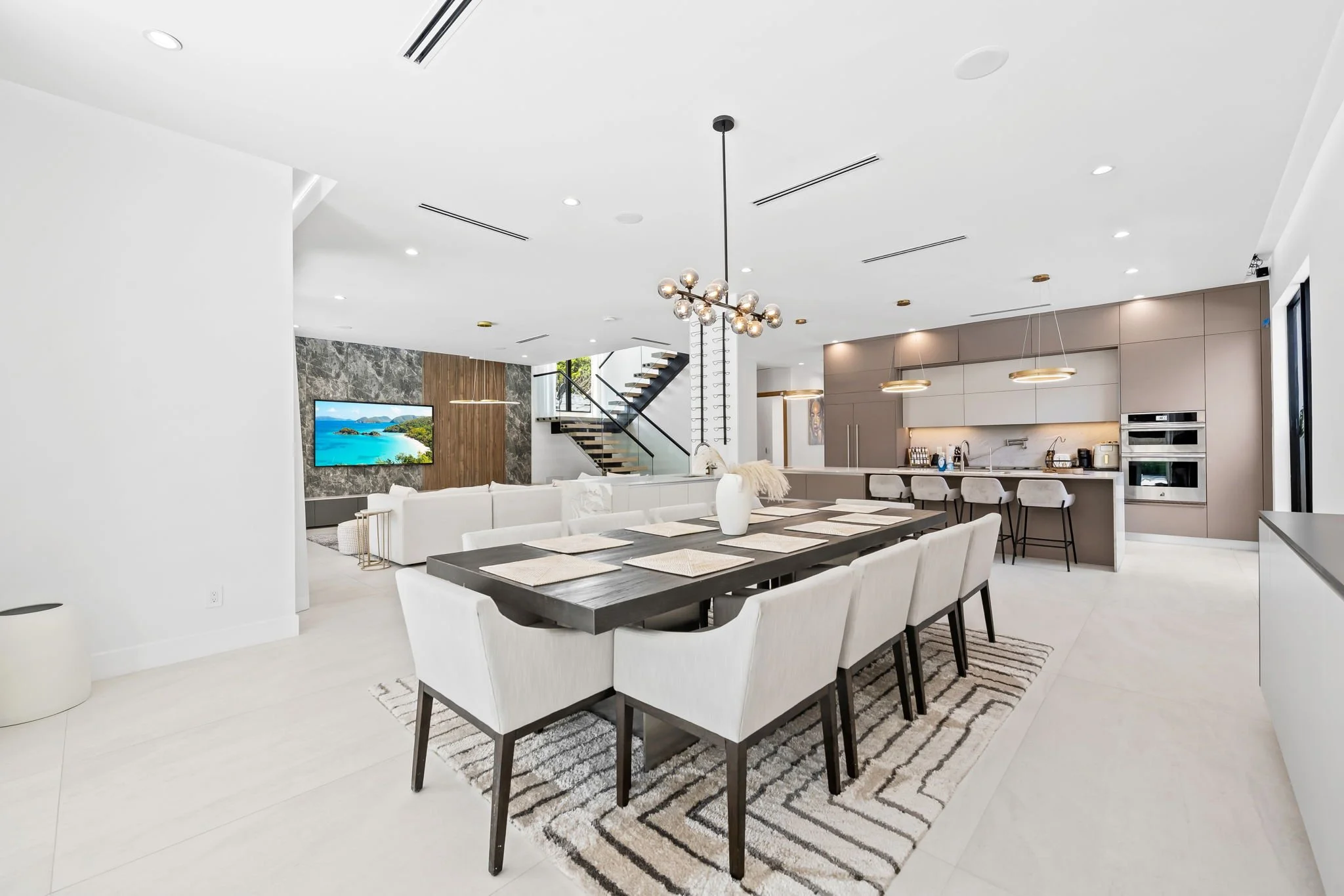 Open-concept kitchen and living area with modern finishes and coastal decor — Sun Haven Collection design-forward vacation home.