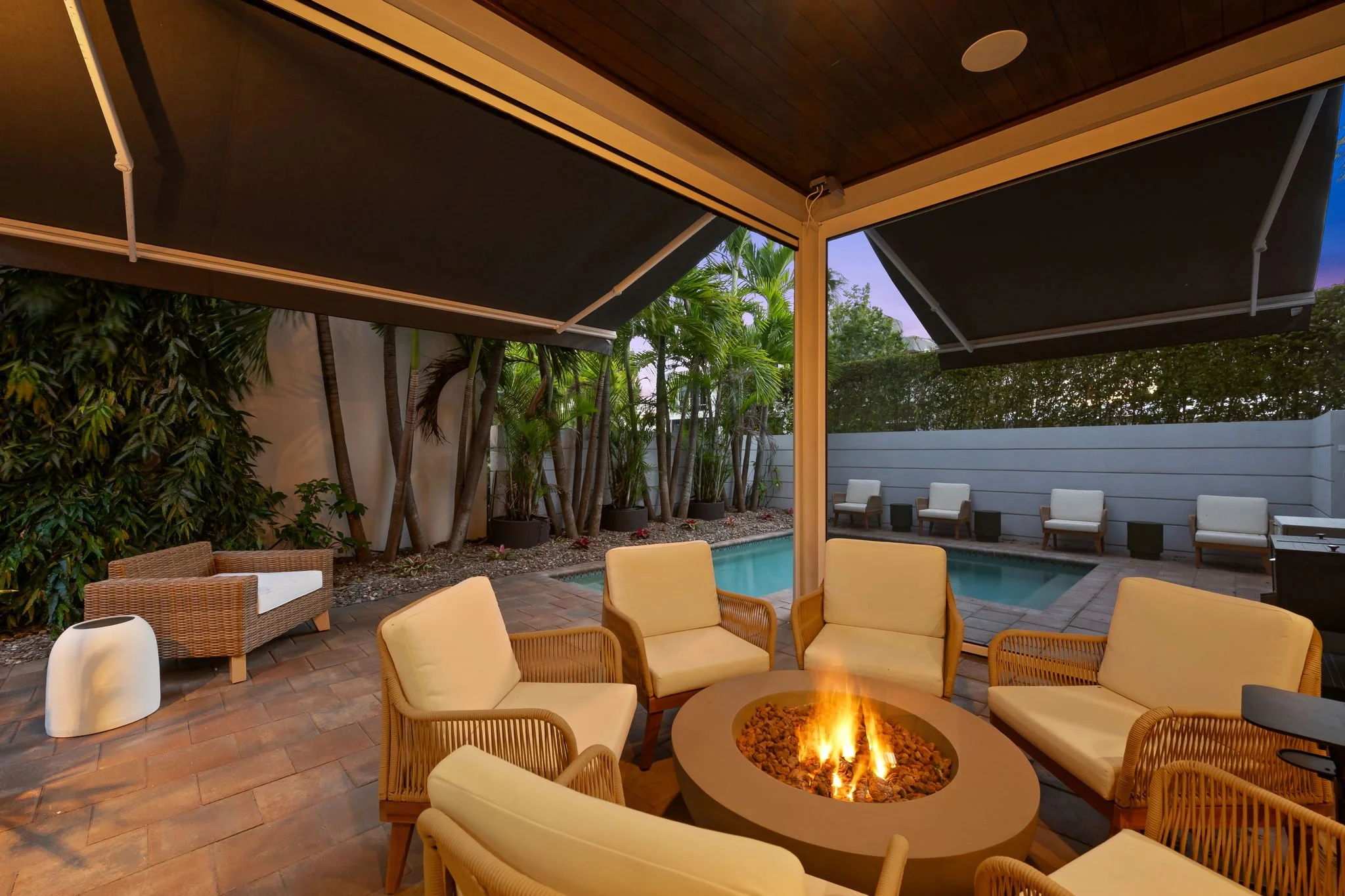 Luxury home with illuminated patio and pool at dusk — Sun Haven Collection vacation rental.