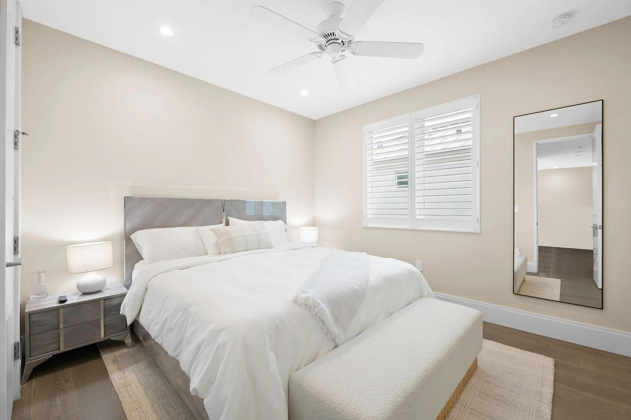 King bedroom with ceiling fan and shuttered windows — Sun Haven Collection luxury vacation rental.