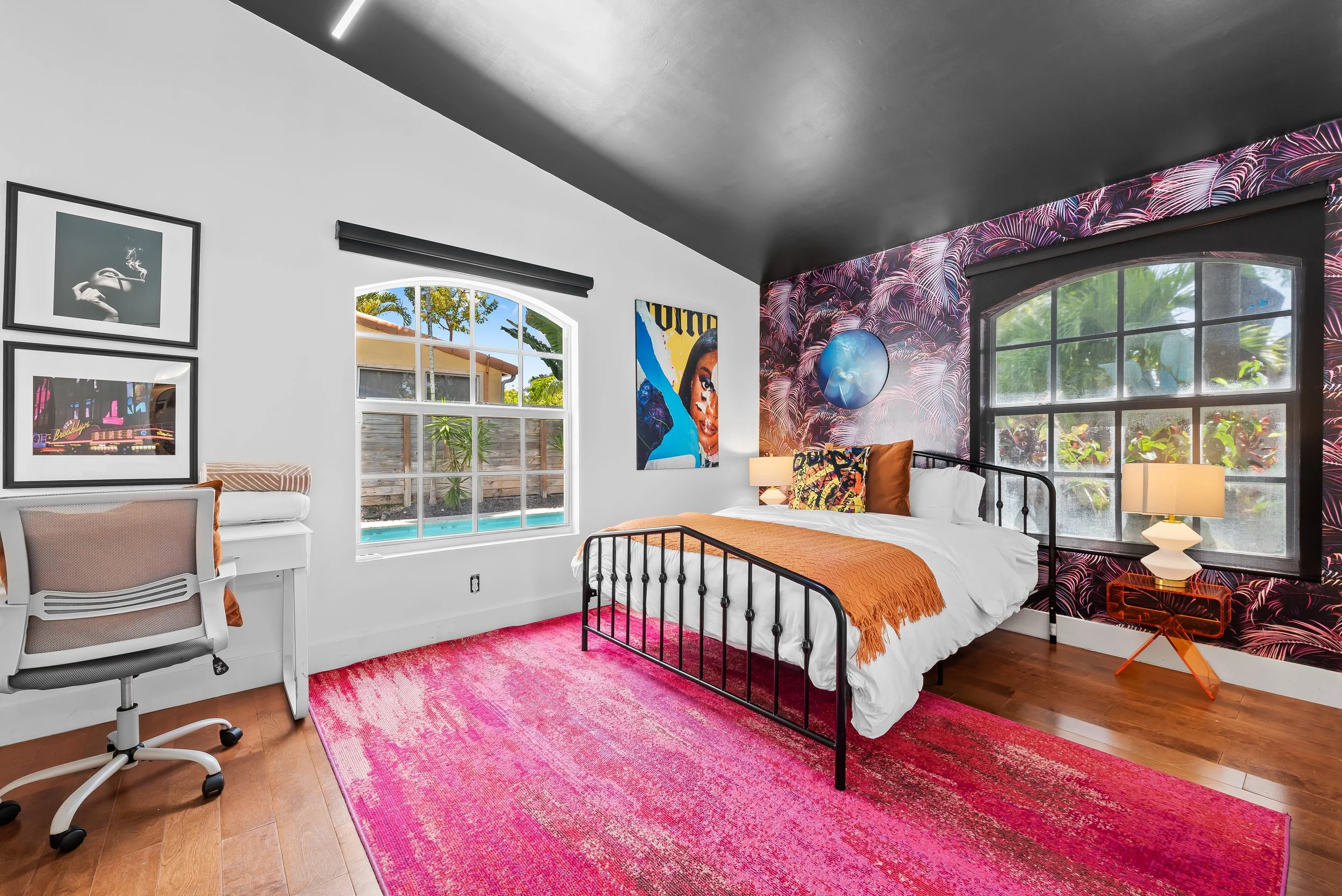 Colorful bedroom with curated artwork and tropical garden views — luxury vacation rental by Sun Haven Collection.
