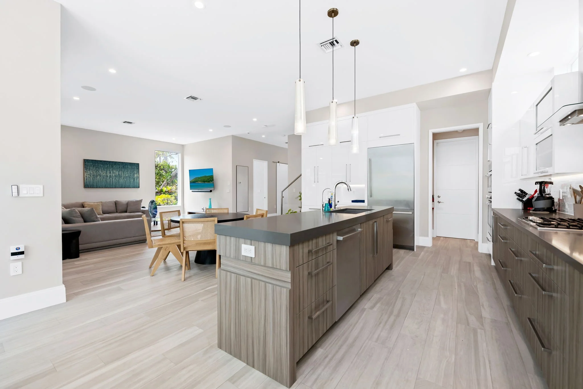 Open-concept kitchen and living room with designer finishes — Sun Haven Collection luxury vacation rental.