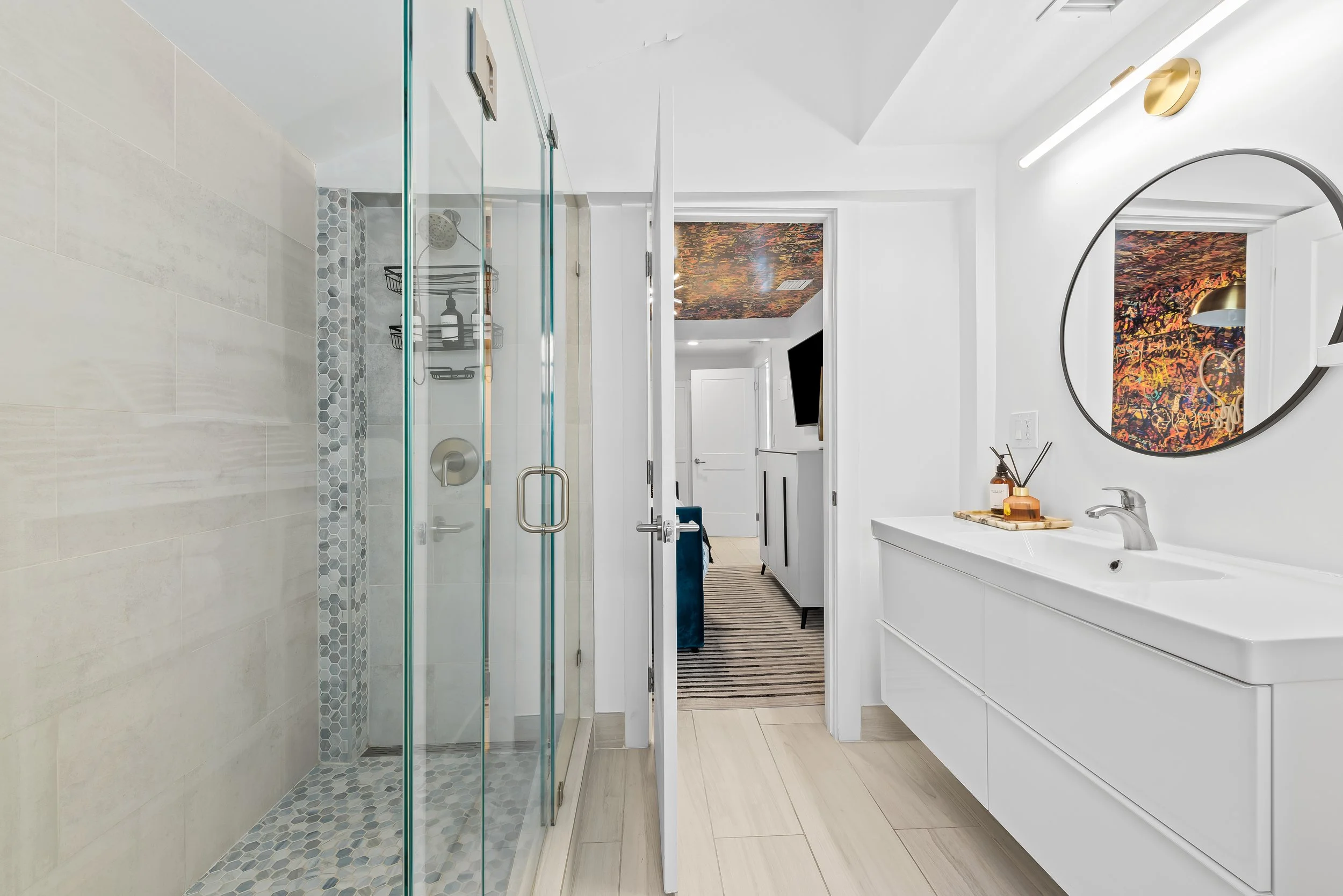 Modern bathroom with glass shower and pop art decor — Sun Haven Collection luxury vacation home.