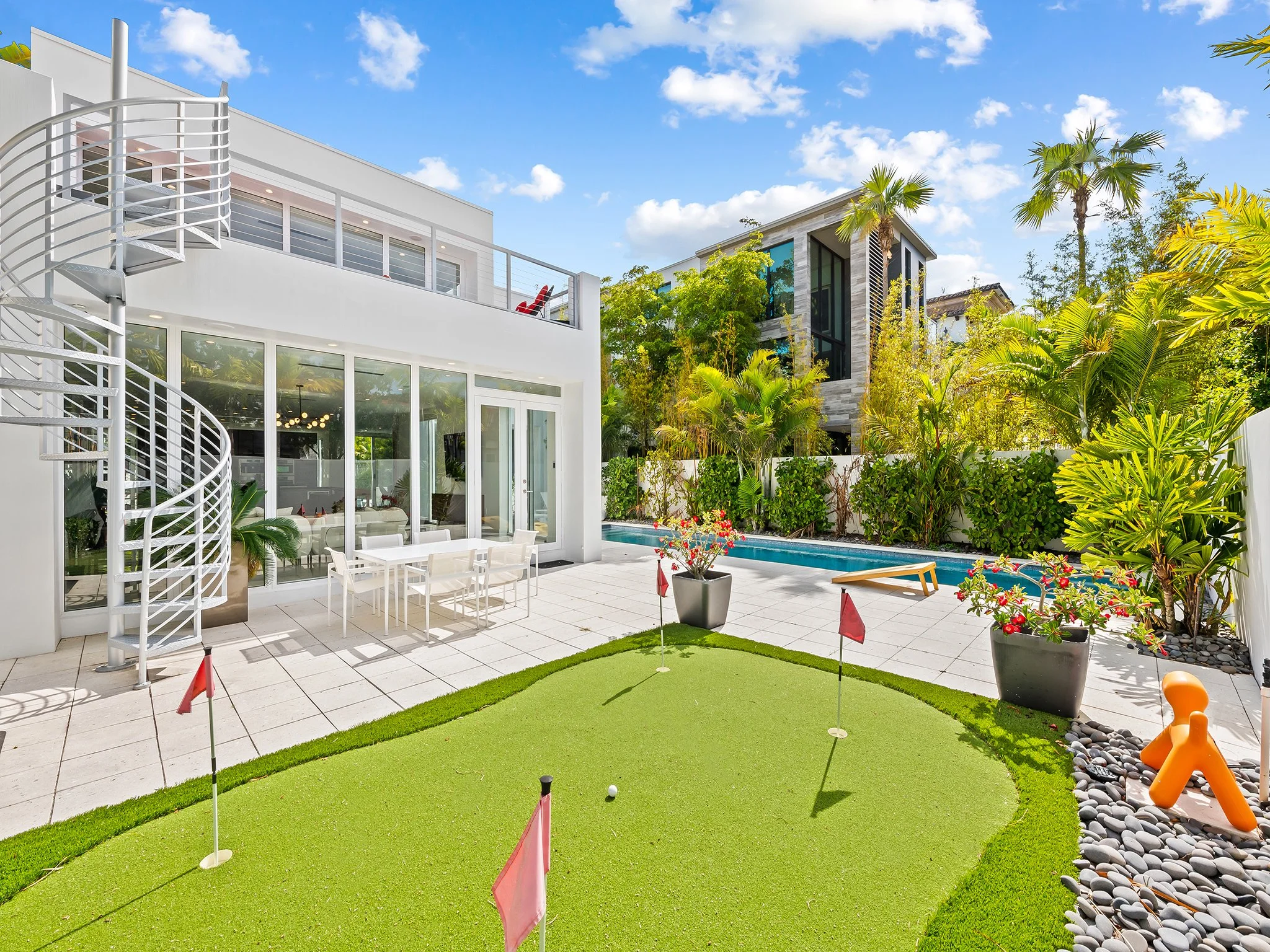 Modern vacation home with pool, outdoor dining, and palm trees — luxury rental by Sun Haven Collection.