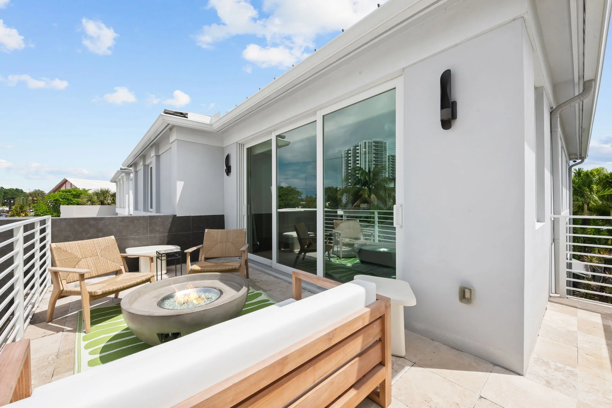 Rooftop balcony with fire pit and city skyline views — Sun Haven Collection luxury vacation rental.