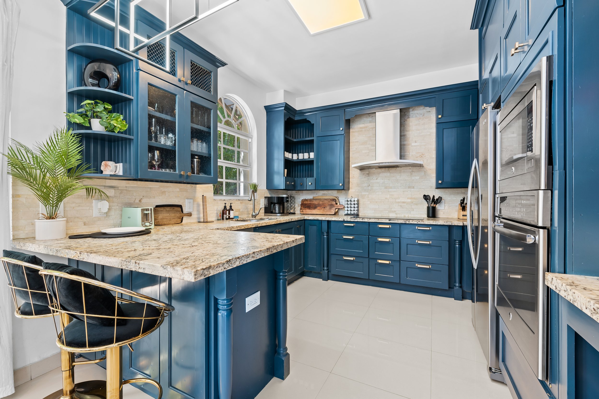 Designer kitchen with blue cabinetry and granite countertops — Sun Haven Collection luxury vacation home.