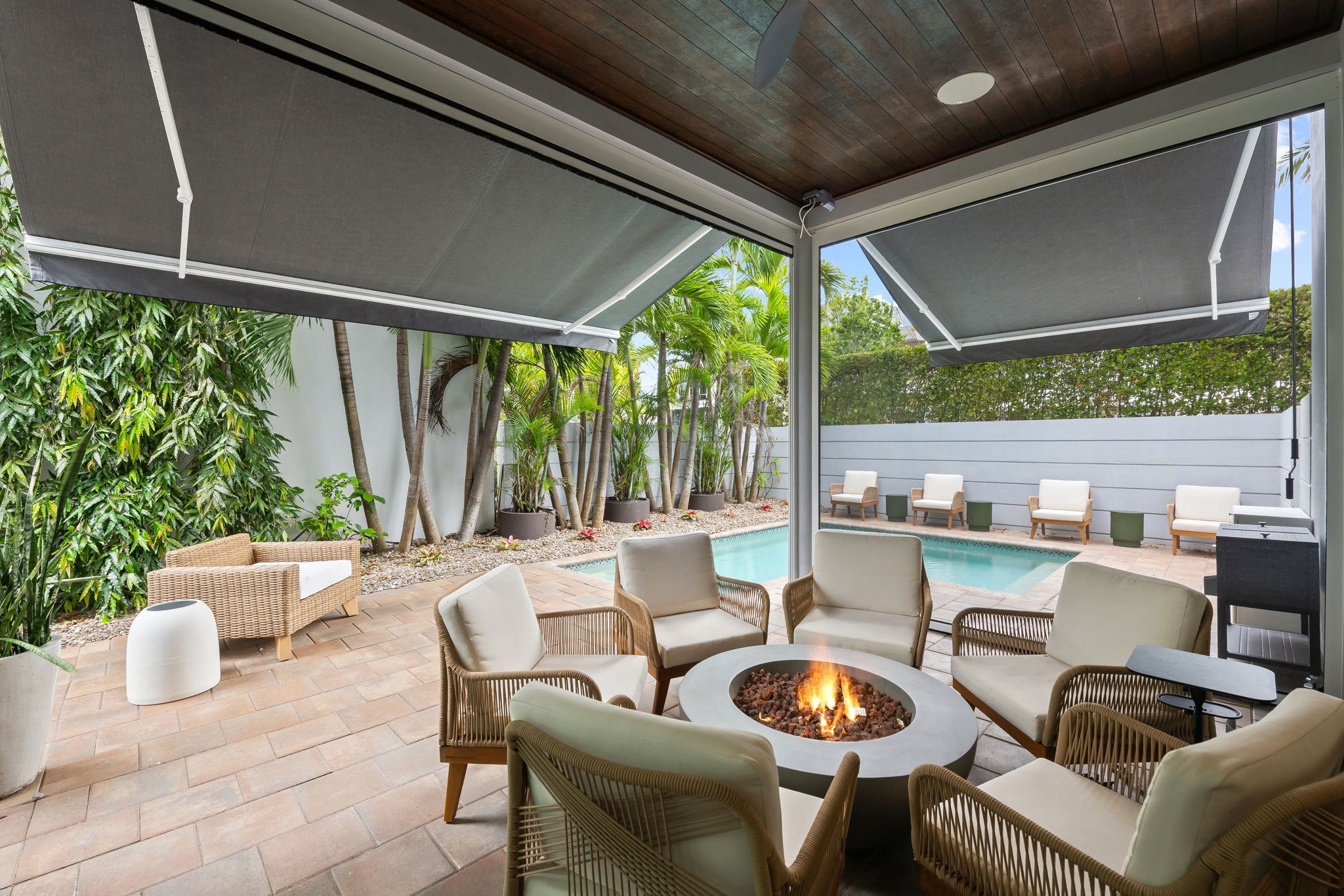 Covered patio with fire pit and private pool — Sun Haven Collection luxury vacation rental amenity.